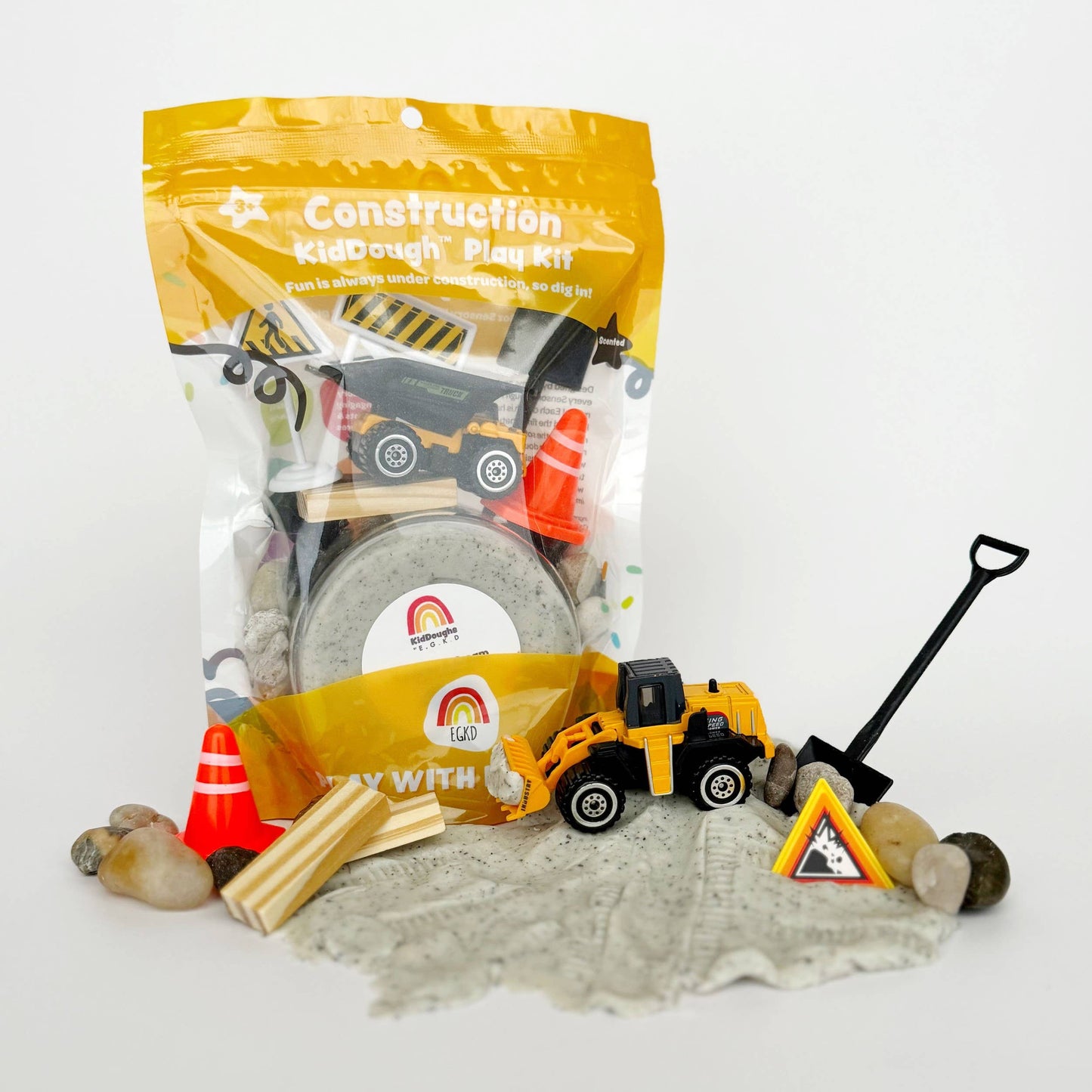 Construction-themed play kit with toys and packaging on a white background