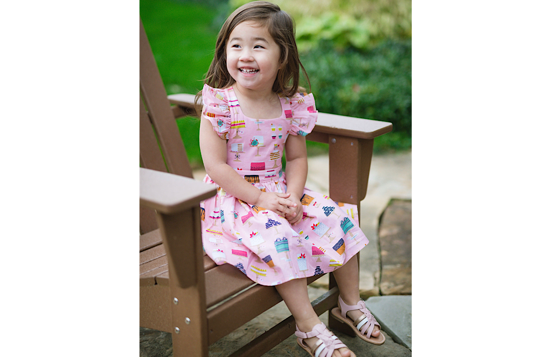 girl sitting in chair wearing cake dress