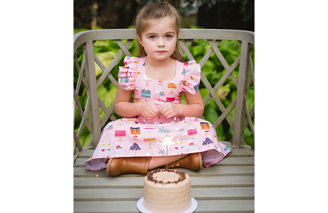 girl sitting with cake while wearing cake dress