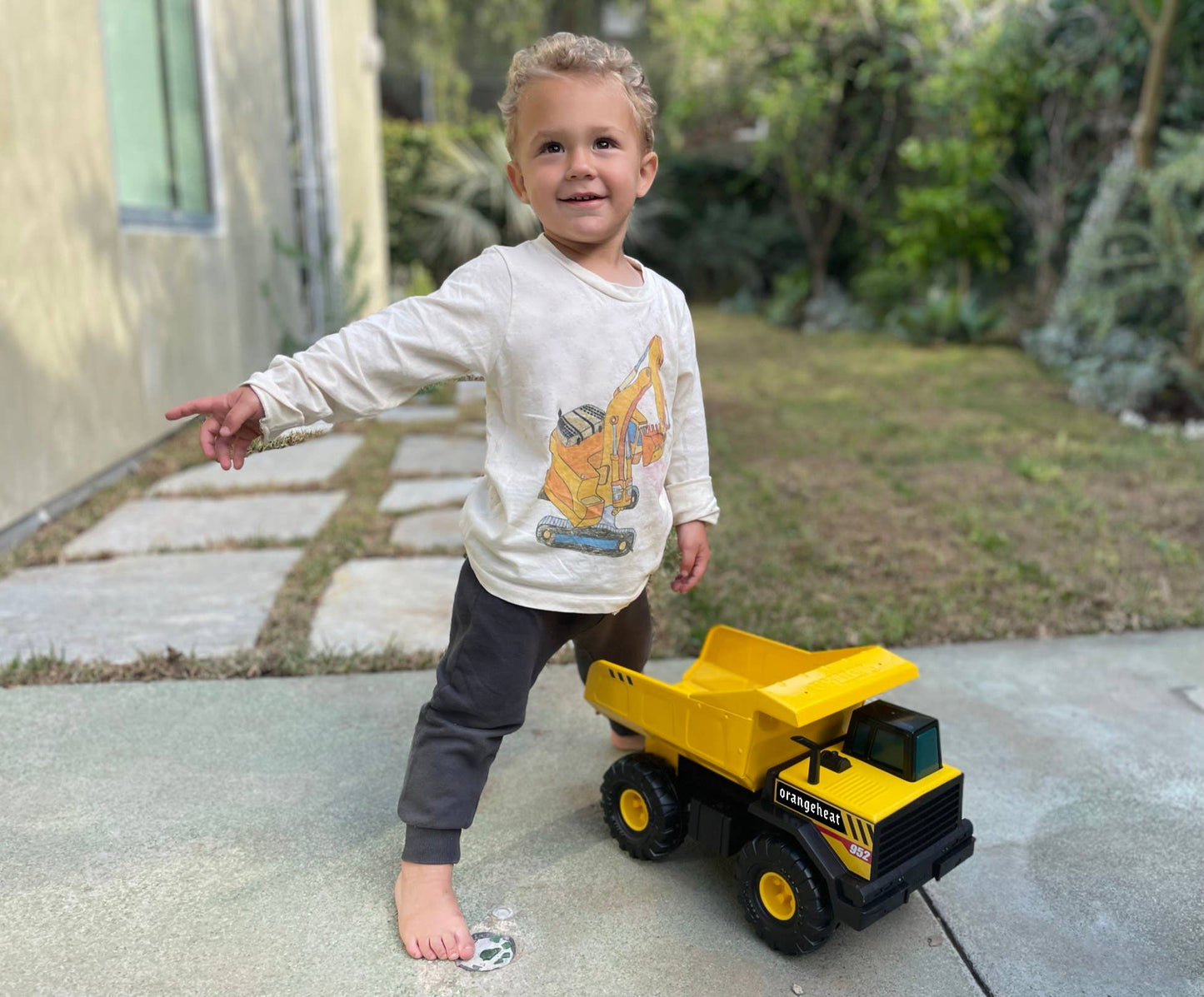 Child playing with a toy dump truck outdoors