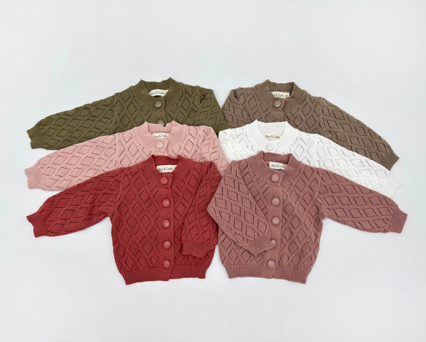 Five children's cardigans in different colors on a light gray background