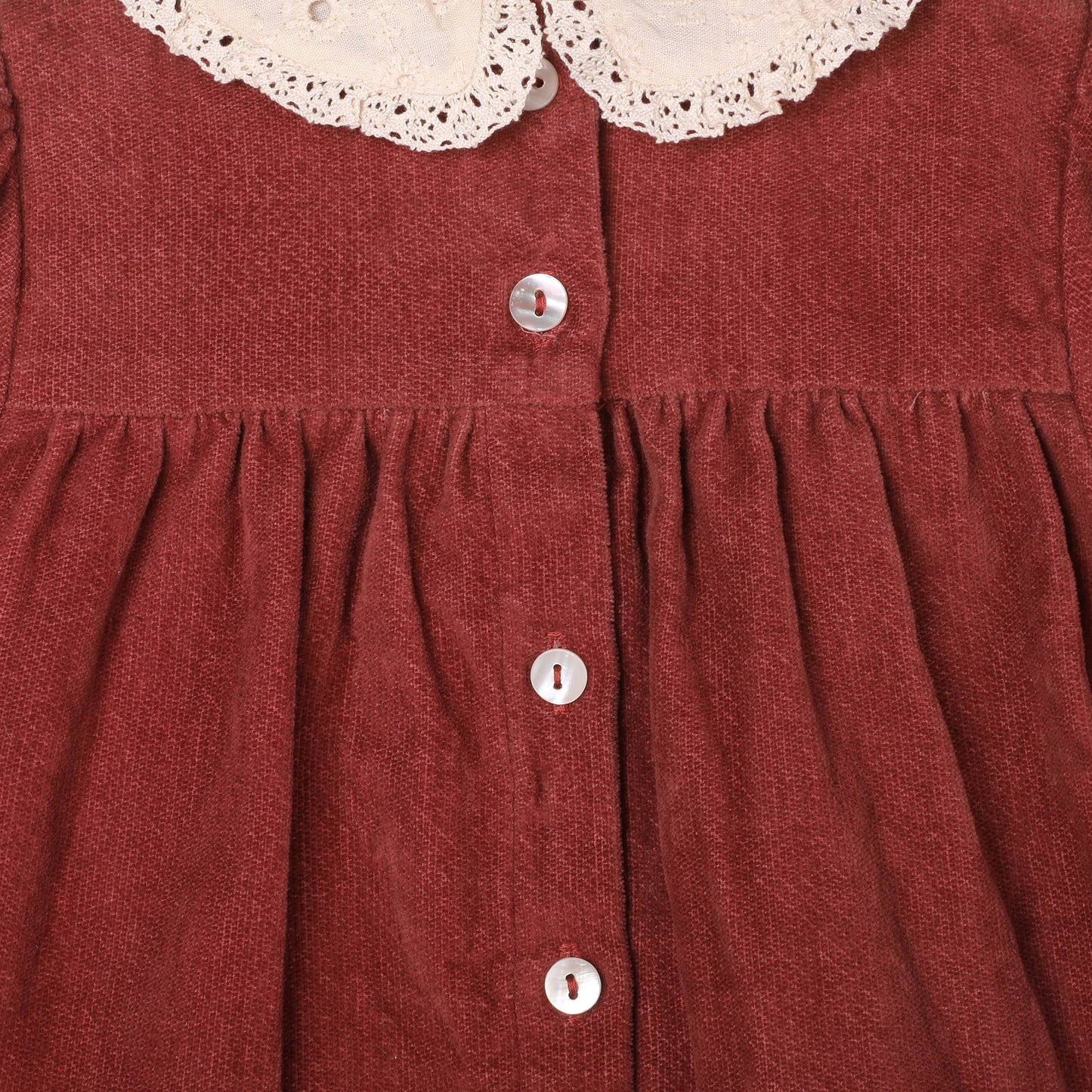 Red dress with lace collar and buttons on a plain background