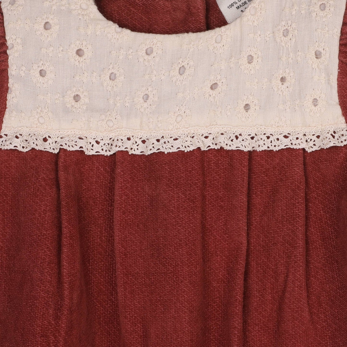 Red dress with white lace trim on a red background