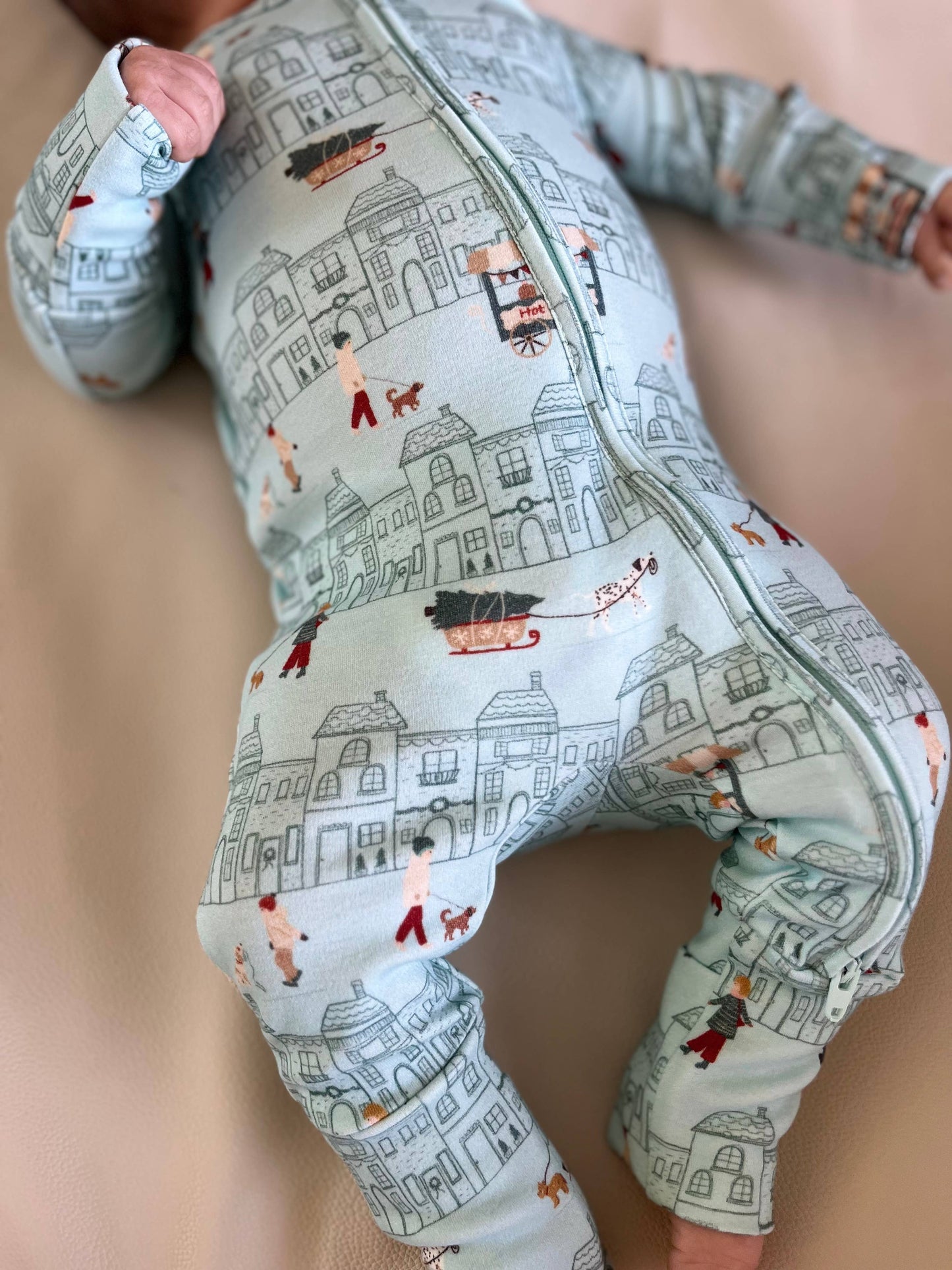 Baby wearing a onesie with a cityscape pattern