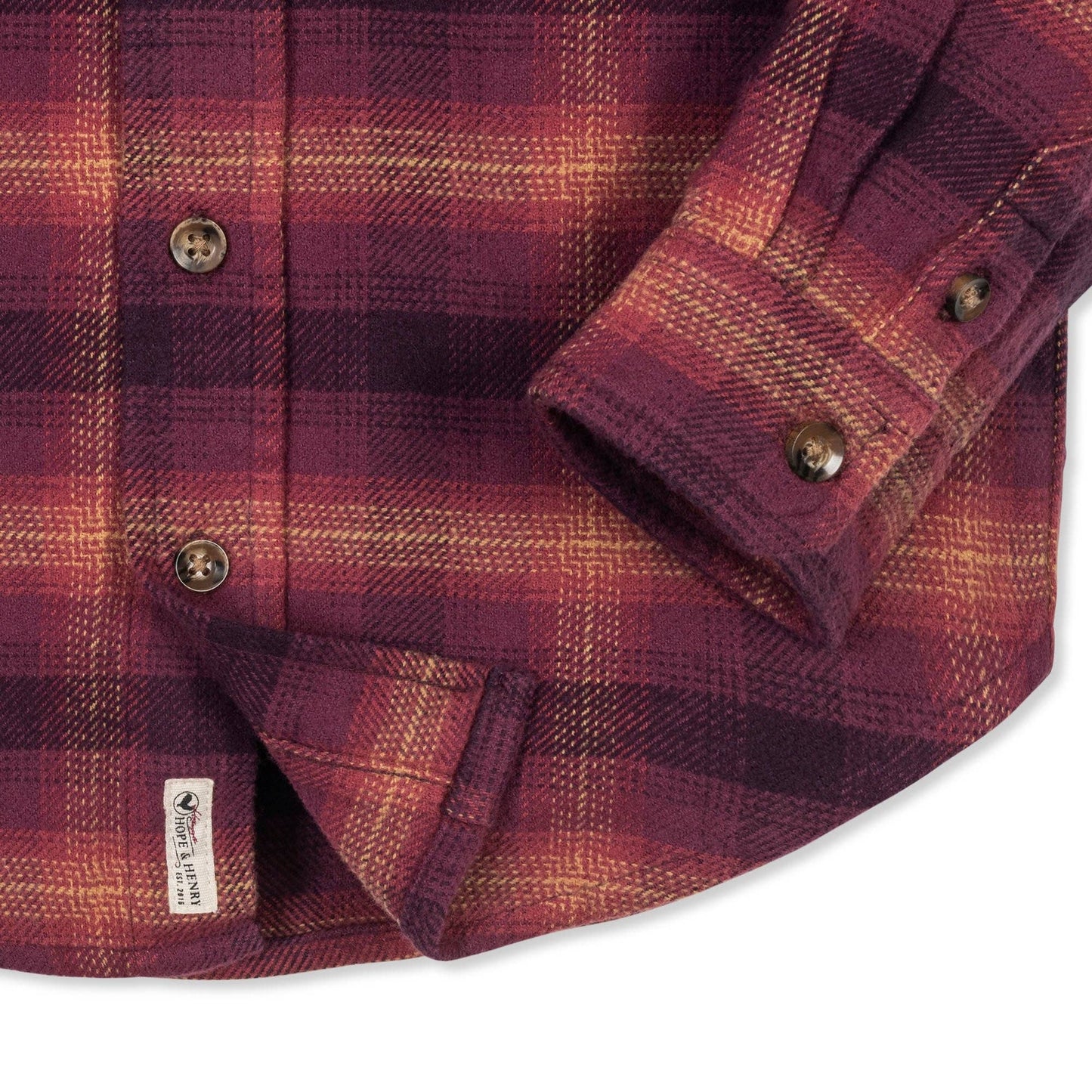 Close-up of a red and brown plaid shirt with buttons on a white background