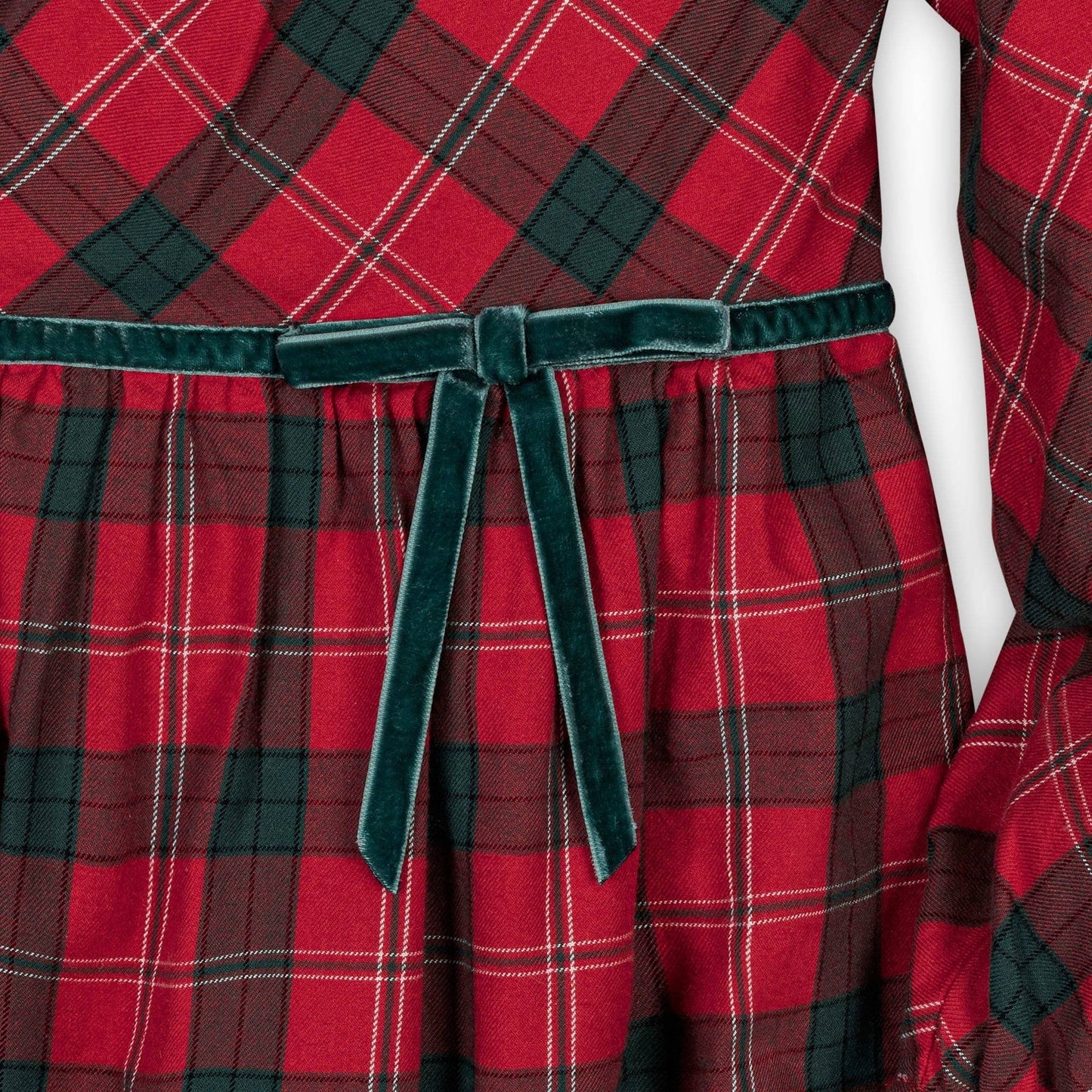 Red and green plaid dress with a velvet belt on a mannequin.