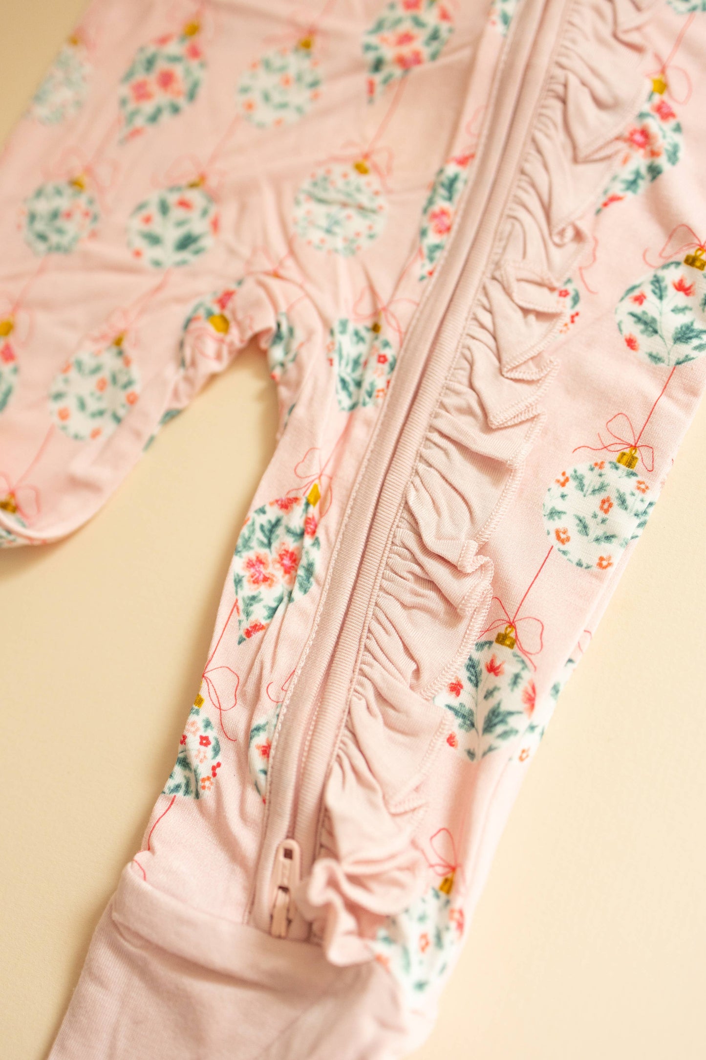 Pink floral-patterned jacket with a zipper on a beige background