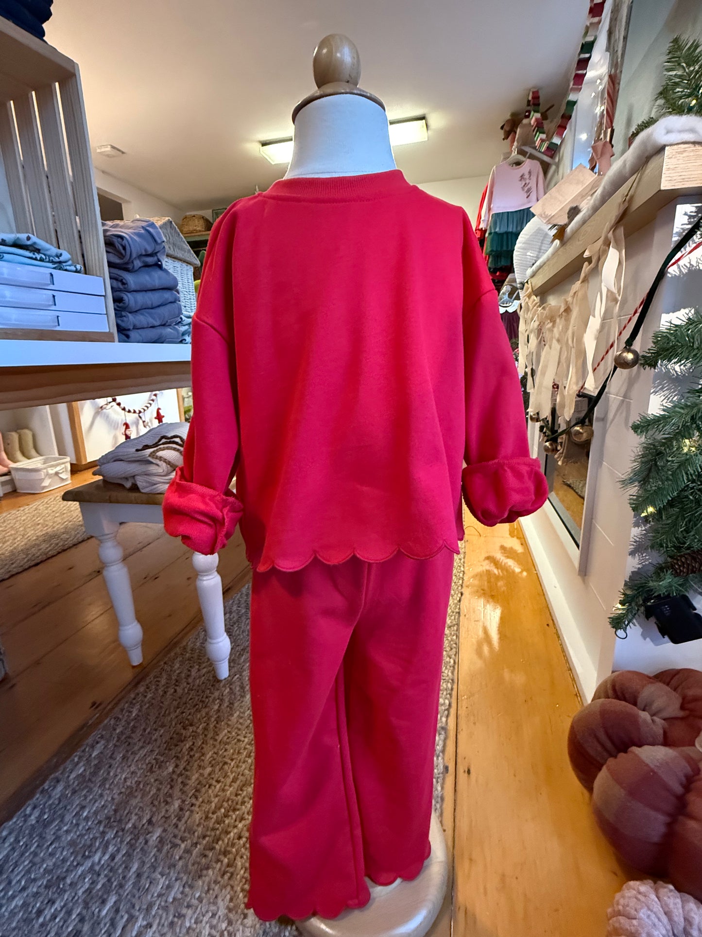 Cherry red two piece sweat suit with scalloped edges on a child mannequin