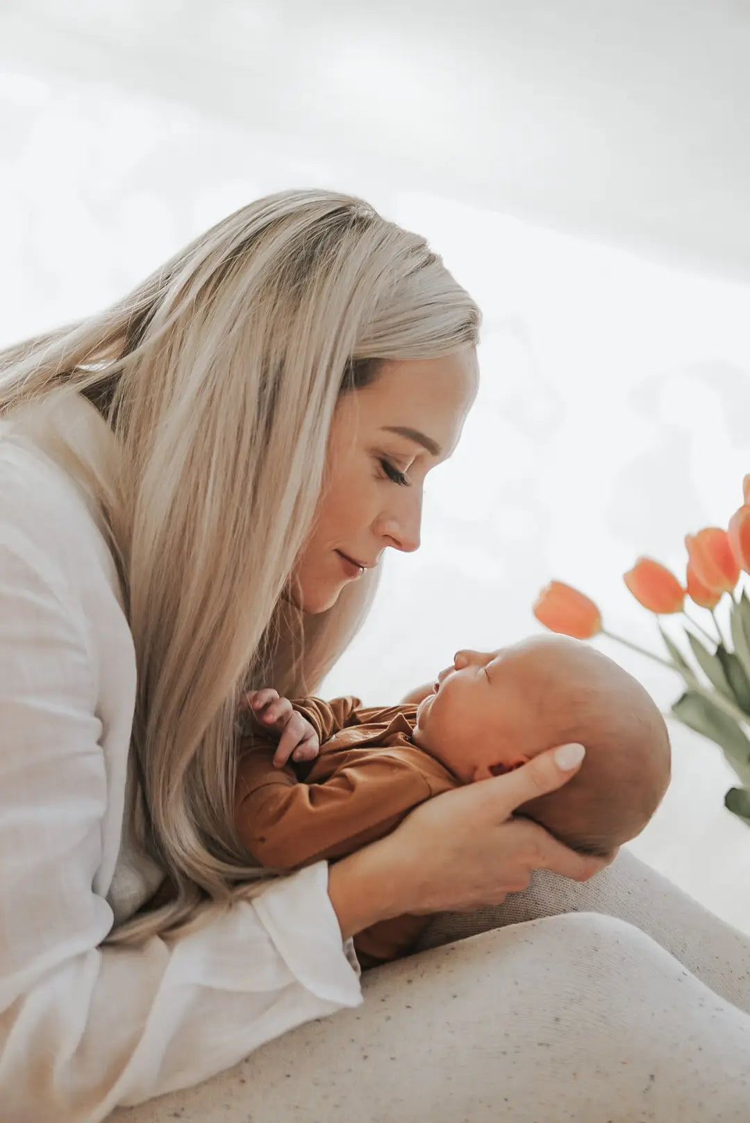 Mom holding newborn in camel outfit