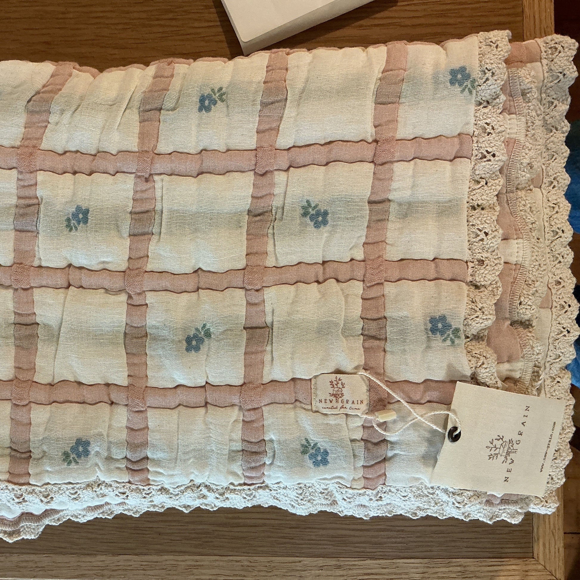 Floral-patterned fabric with lace trim on a wooden surface