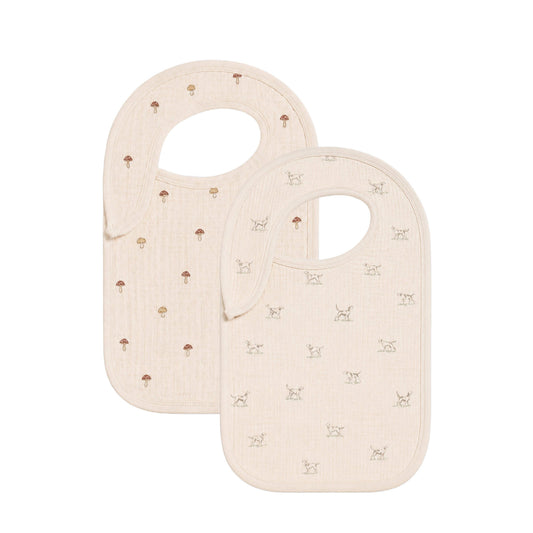 Two beige baby bibs with small patterns on a white background