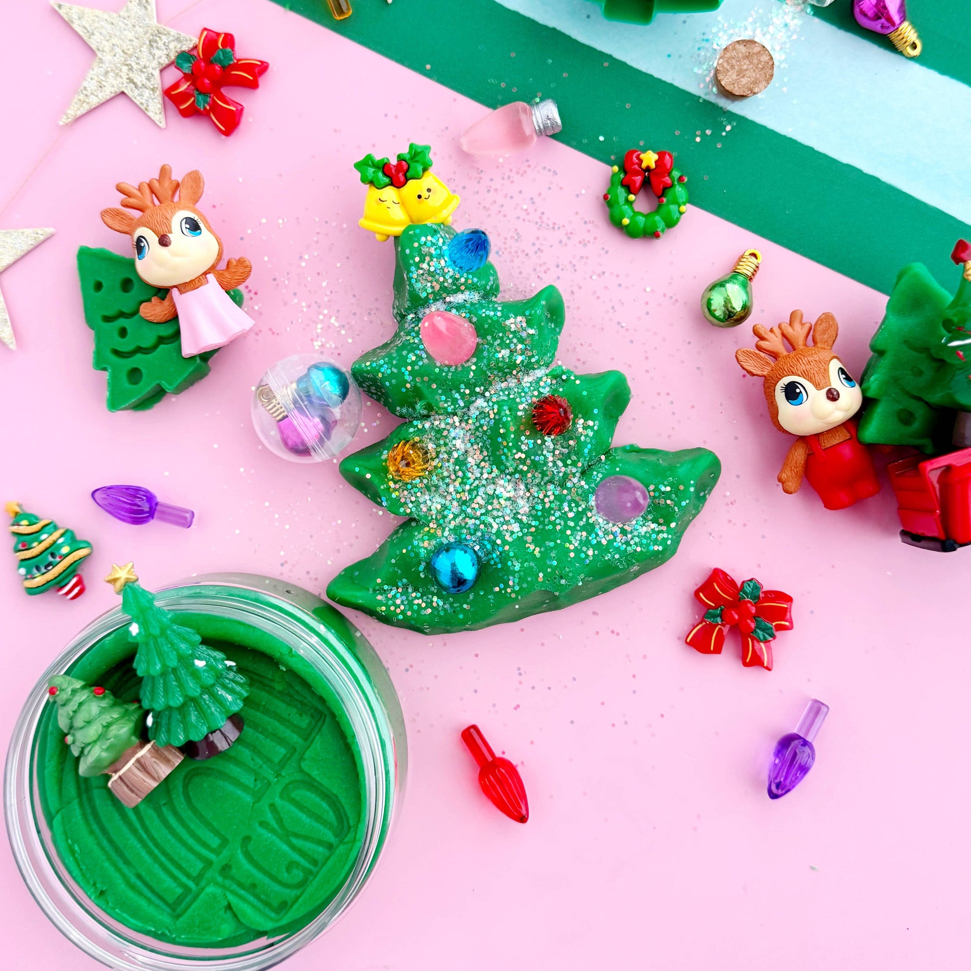 Christmas-themed play dough set with green trees, decorations, and characters on a striped background.