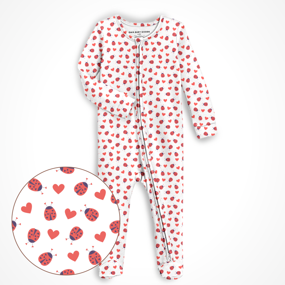 White baby onesie with red heart pattern on a white background