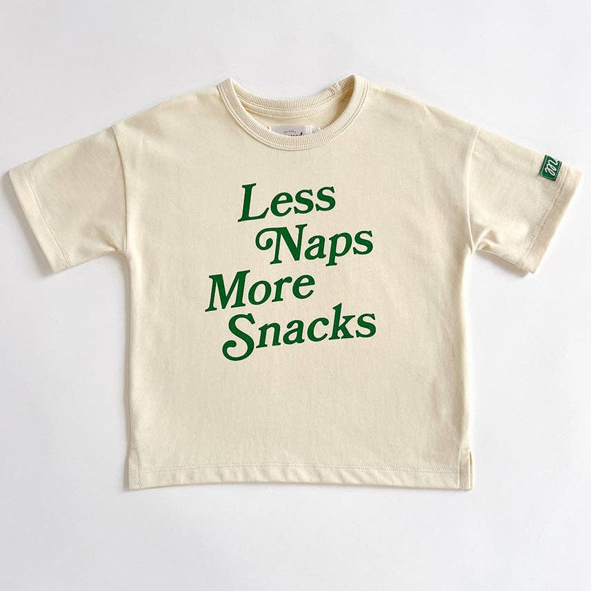 Beige t-shirt with green text 'Less Naps More Snacks' on a white background