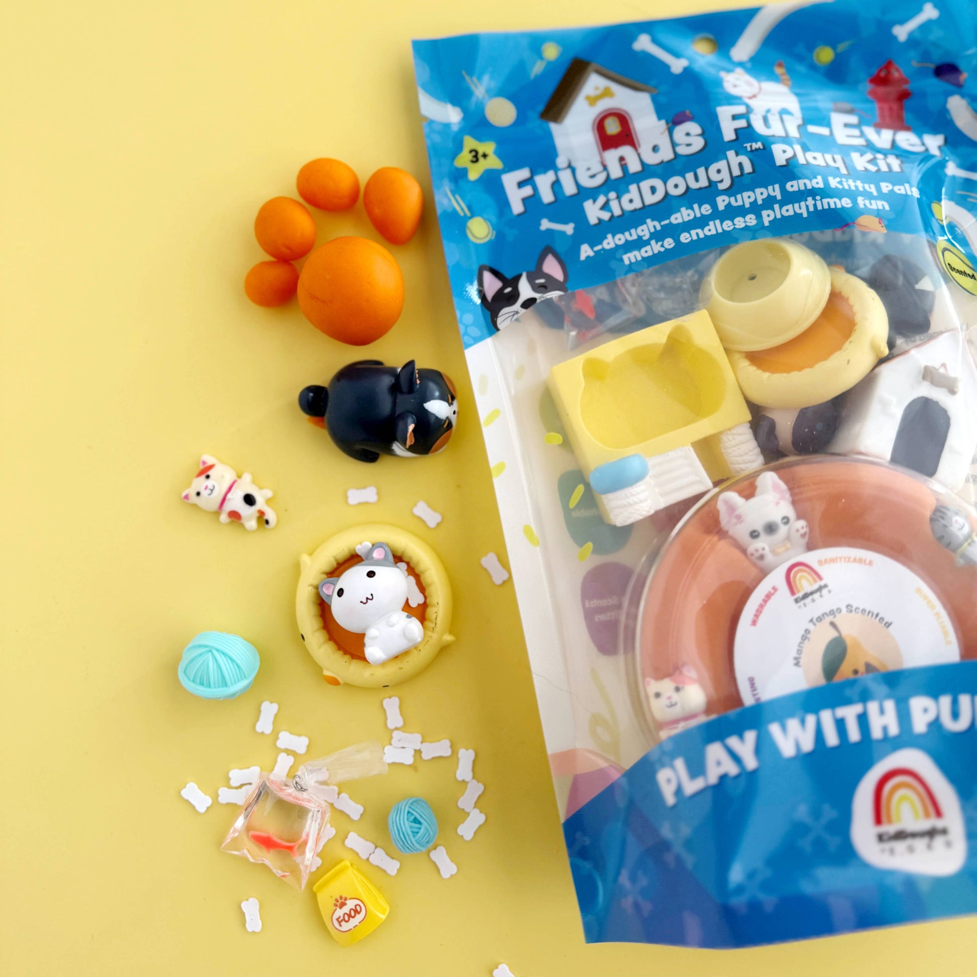 Packaged play dough set with various shaped pieces on a yellow background