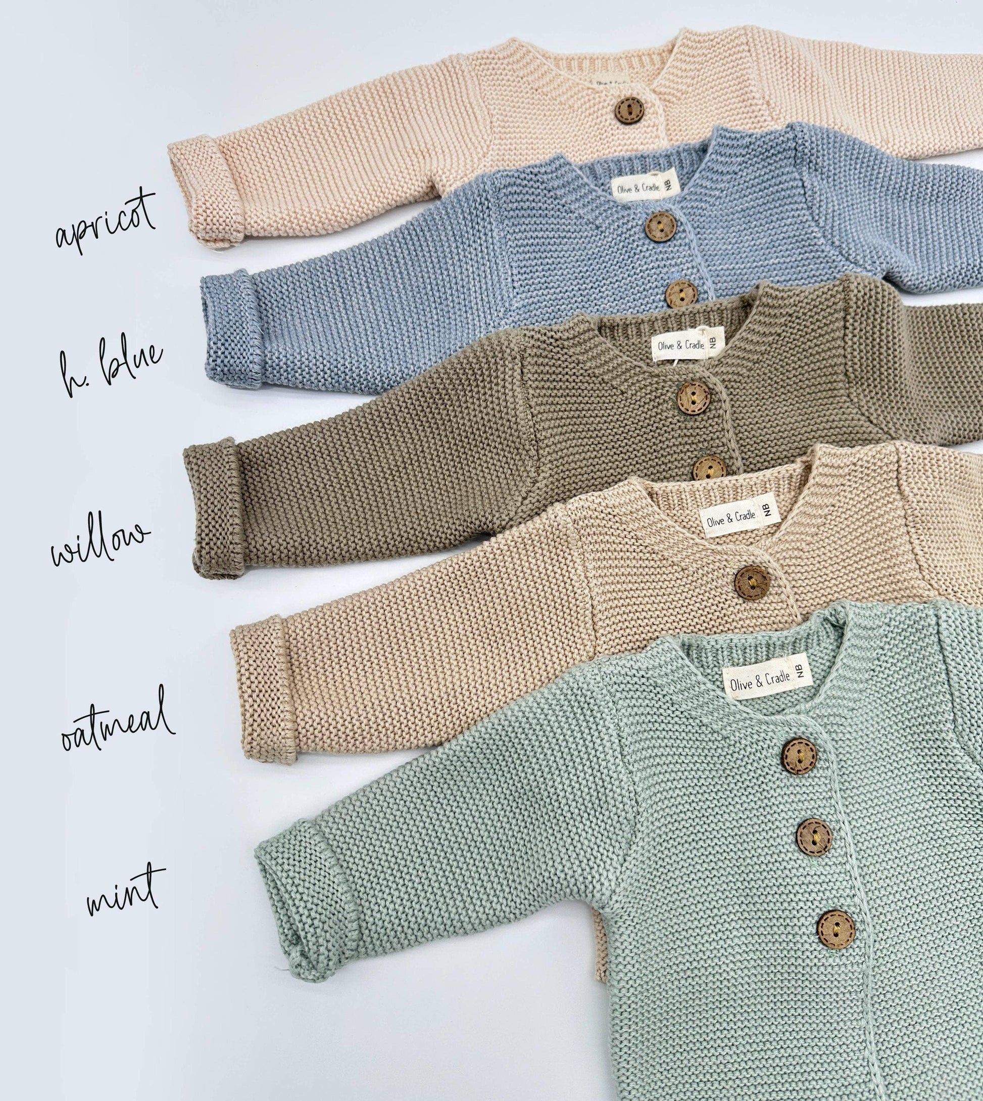 Four baby cardigans in different colors on a light blue background