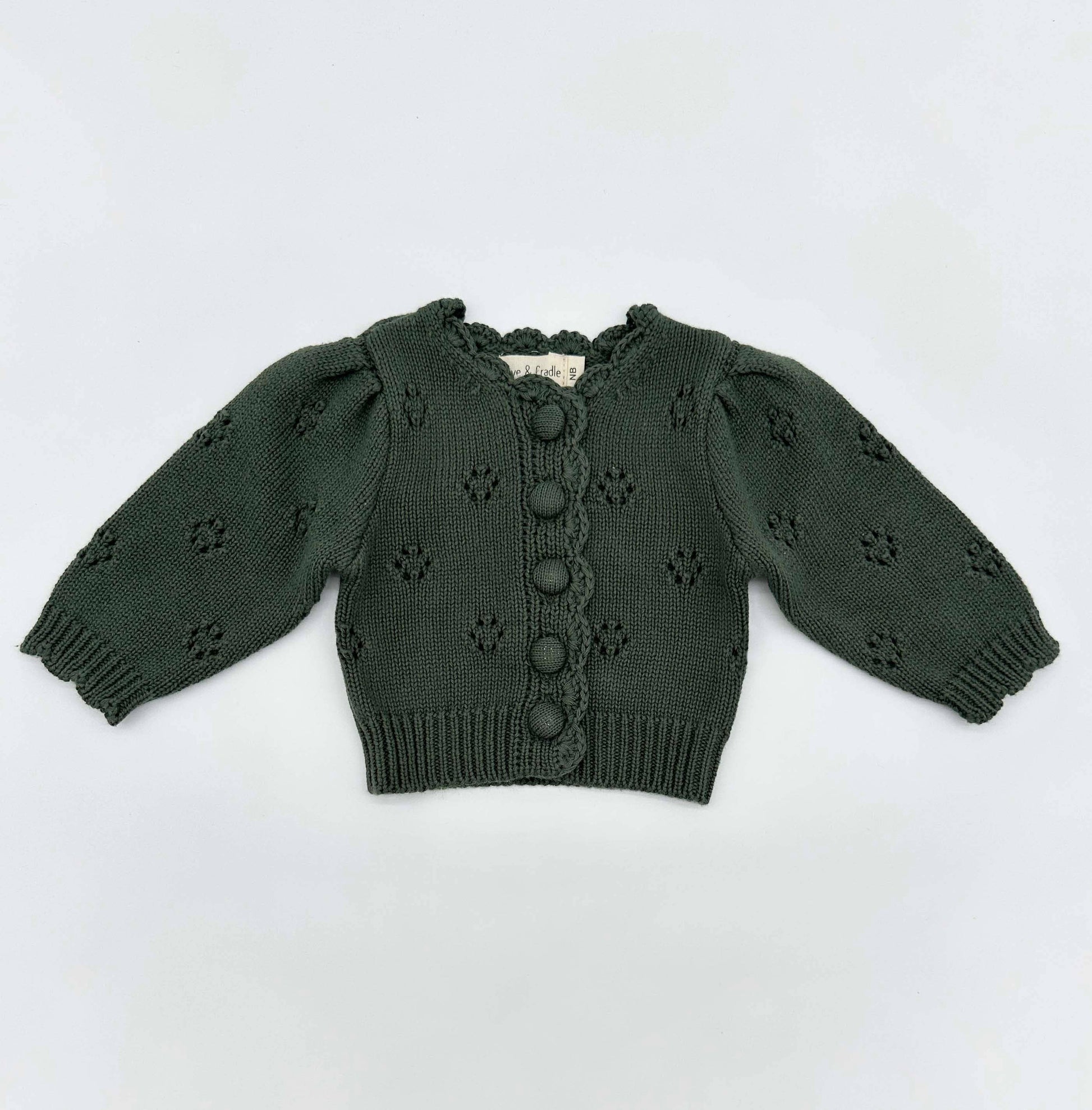 Green knitted cardigan with button details on a white background