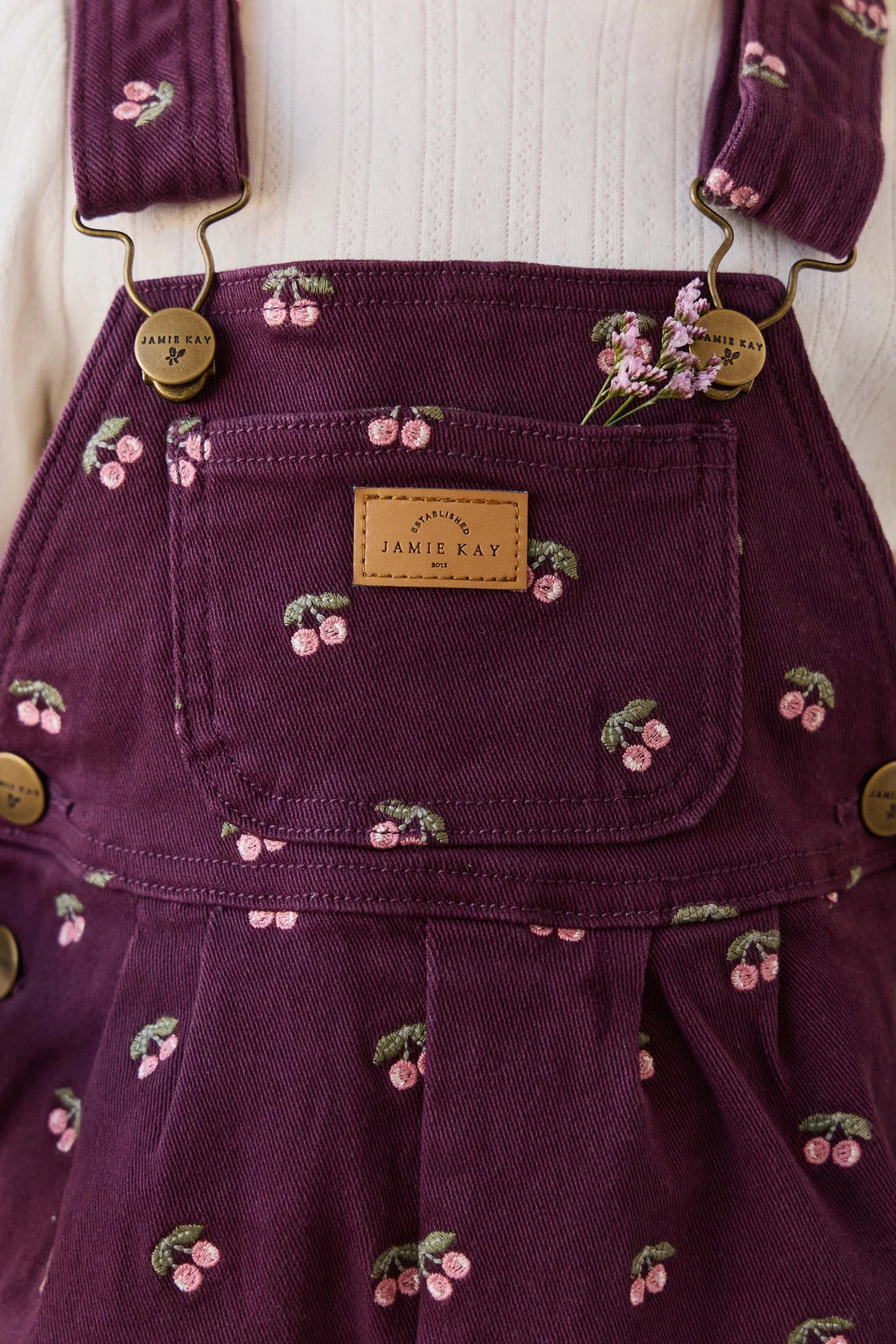Purple children's dress with floral embroidery and 'Jamie Kay' label on a white background