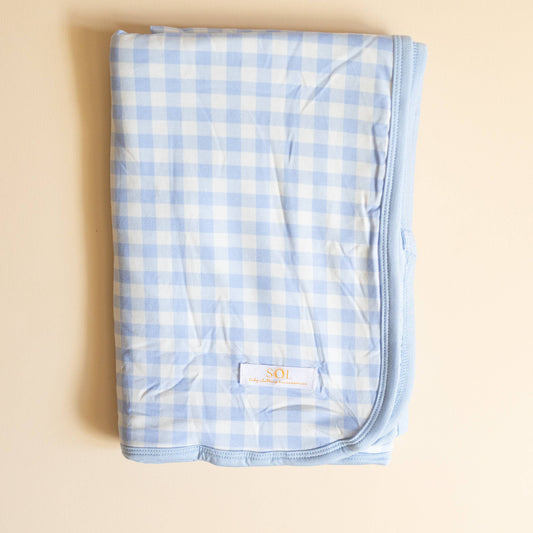 Blue and white checkered blanket on a beige background