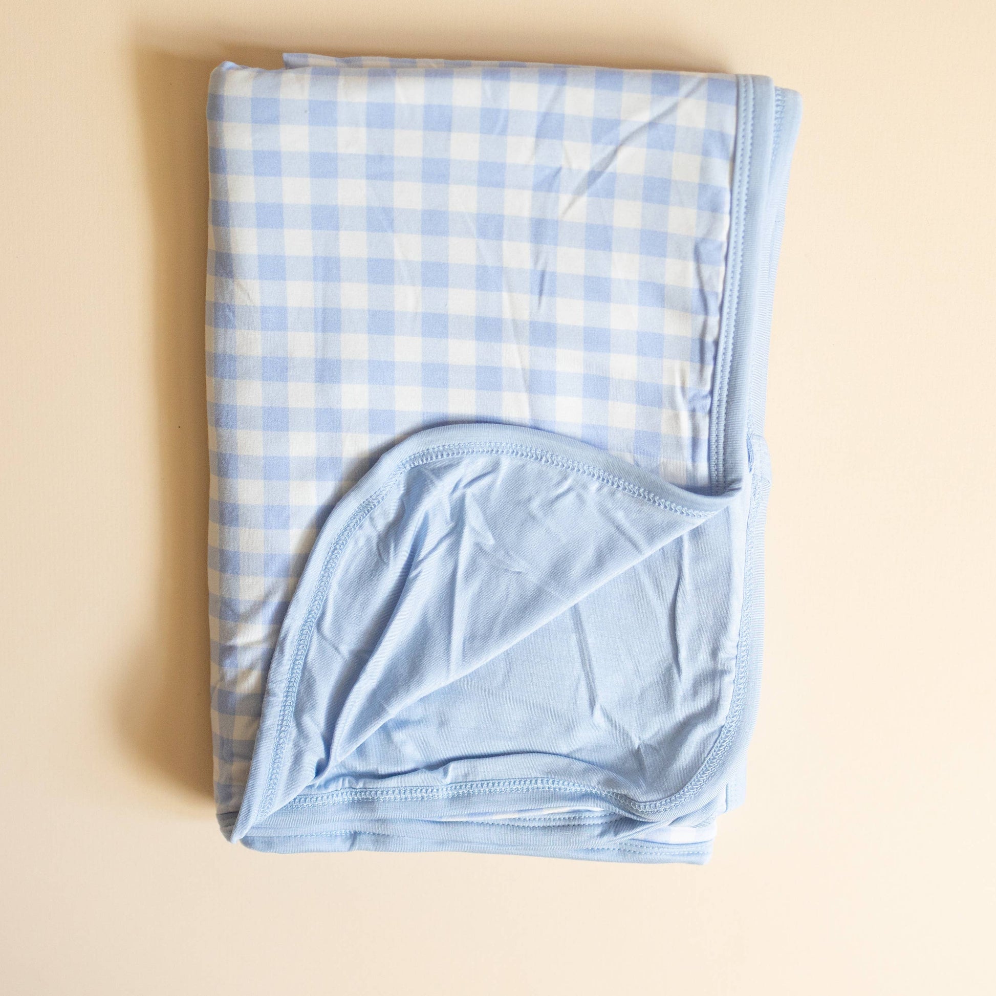 Folded blue checkered fabric on a beige background