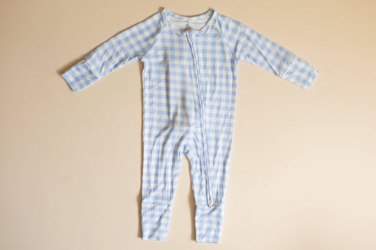 Blue checkered baby onesie on a beige background