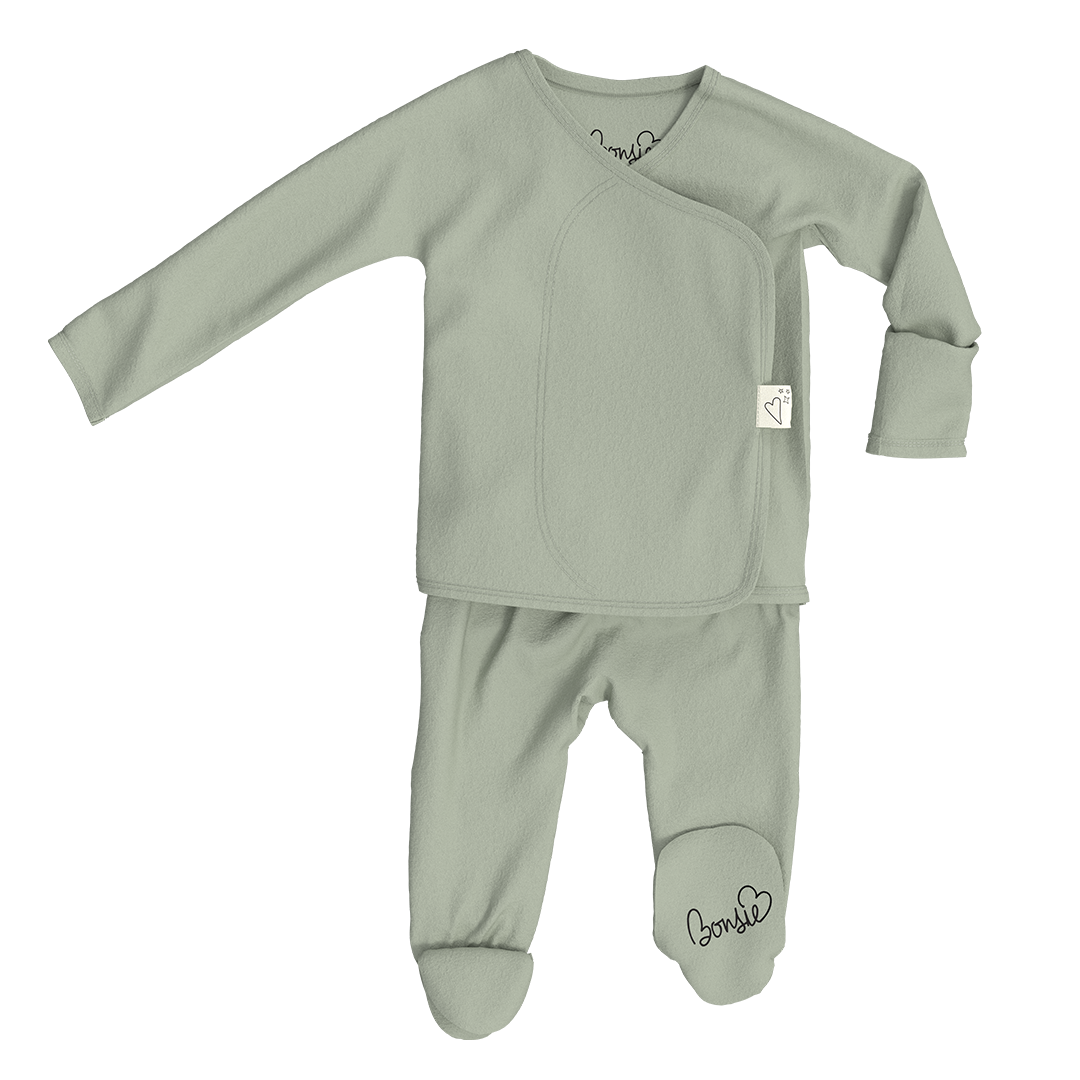 A baby sleepwear set consisting of a long-sleeve wrap top and matching footed pants in a muted sage green color, laid flat on a white background. The brand name 'bonnie+lee' is printed in black script on the inner neck label and the ankle of the pants.