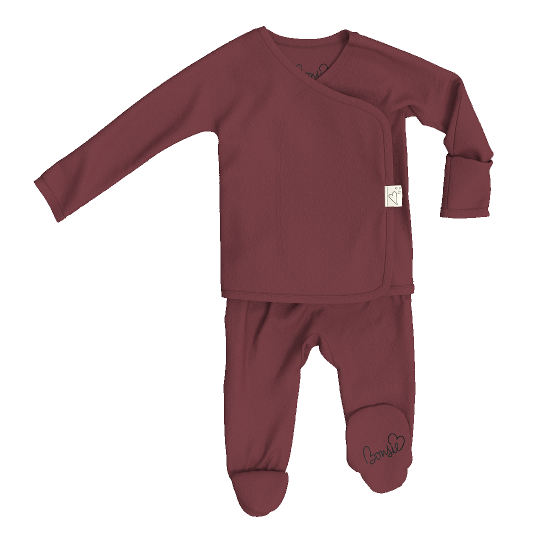 A baby sleepwear set consisting of a long-sleeve wrap-style top and matching footed pants in a dusty burgundy color, shown on a plain white background.