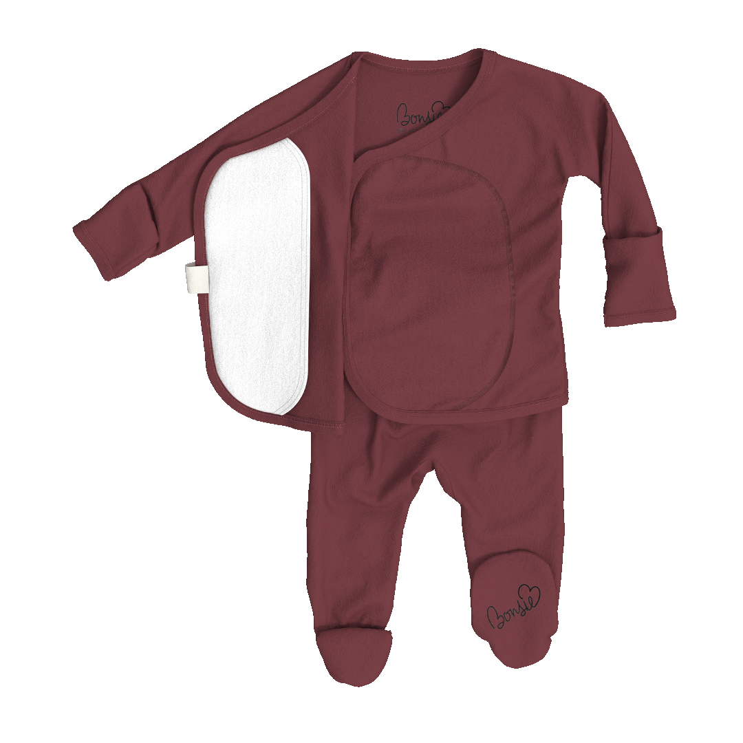 A baby footed sleeper set in a dusty burgundy color, featuring an asymmetrical top with a white fleece-lined panel on the left side and embroidered 'love u' text on the chest and ankle.