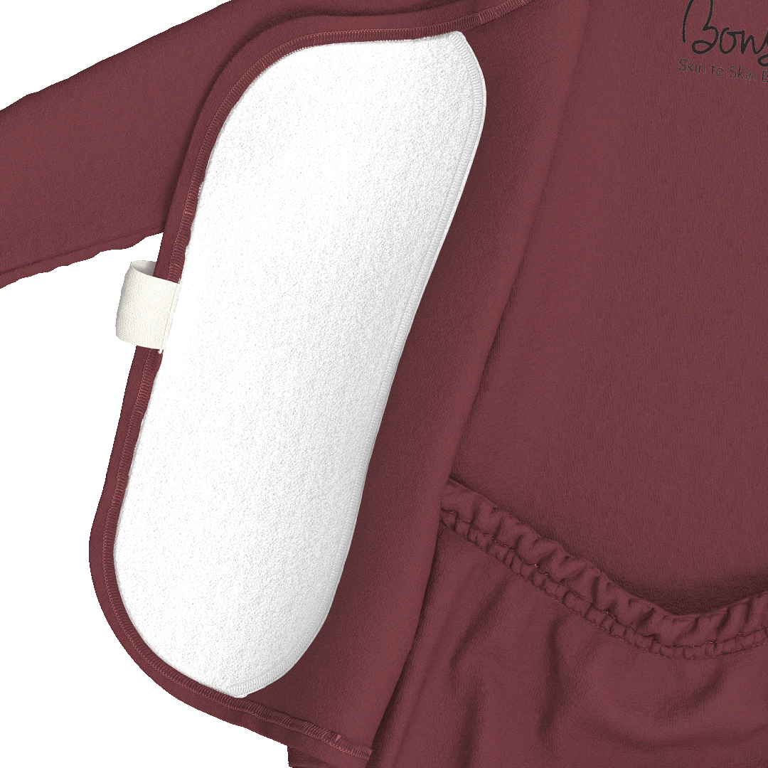 Close-up of a burgundy long-sleeve baby outfit with a white textured underlayer or insert visible along the side seam, plus an elasticated waistband.
