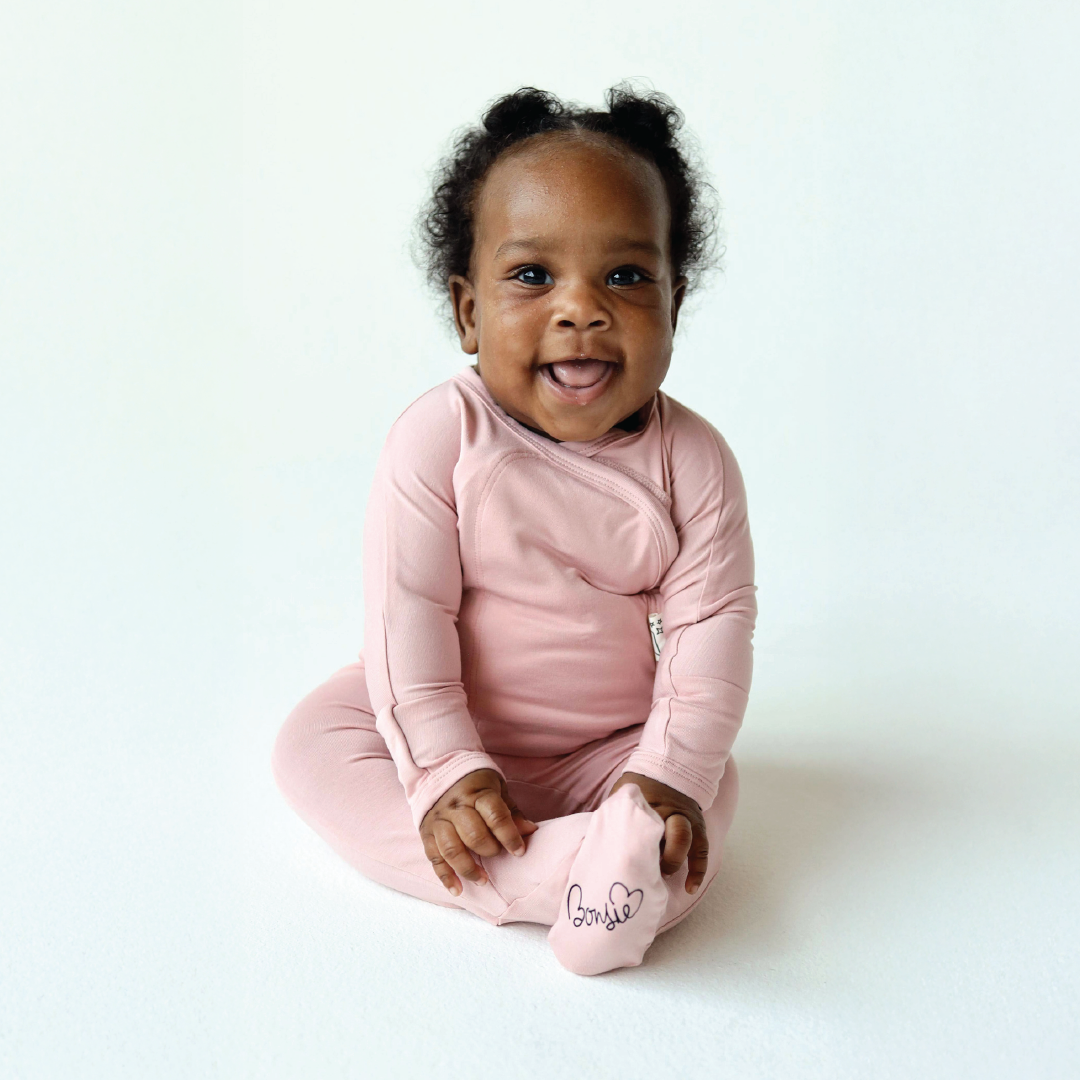 Baby in a pink outfit with 'Goddie' branding on a white background