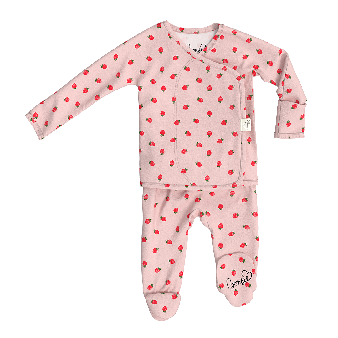 Baby outfit with pink base and red cherry pattern on a white background