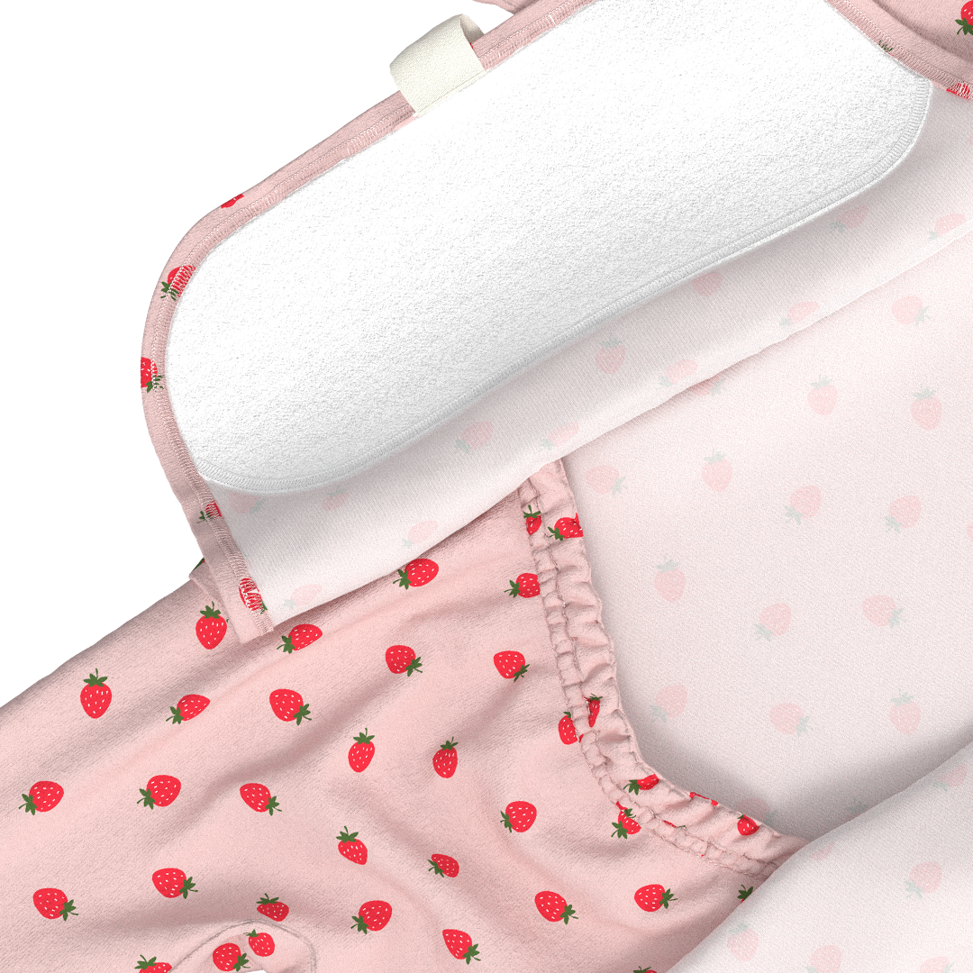 Pink fabric with strawberry pattern and white pillow on a white background