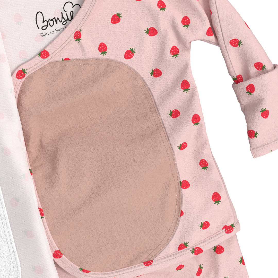 Baby romper with strawberry pattern and brown patch on a white background