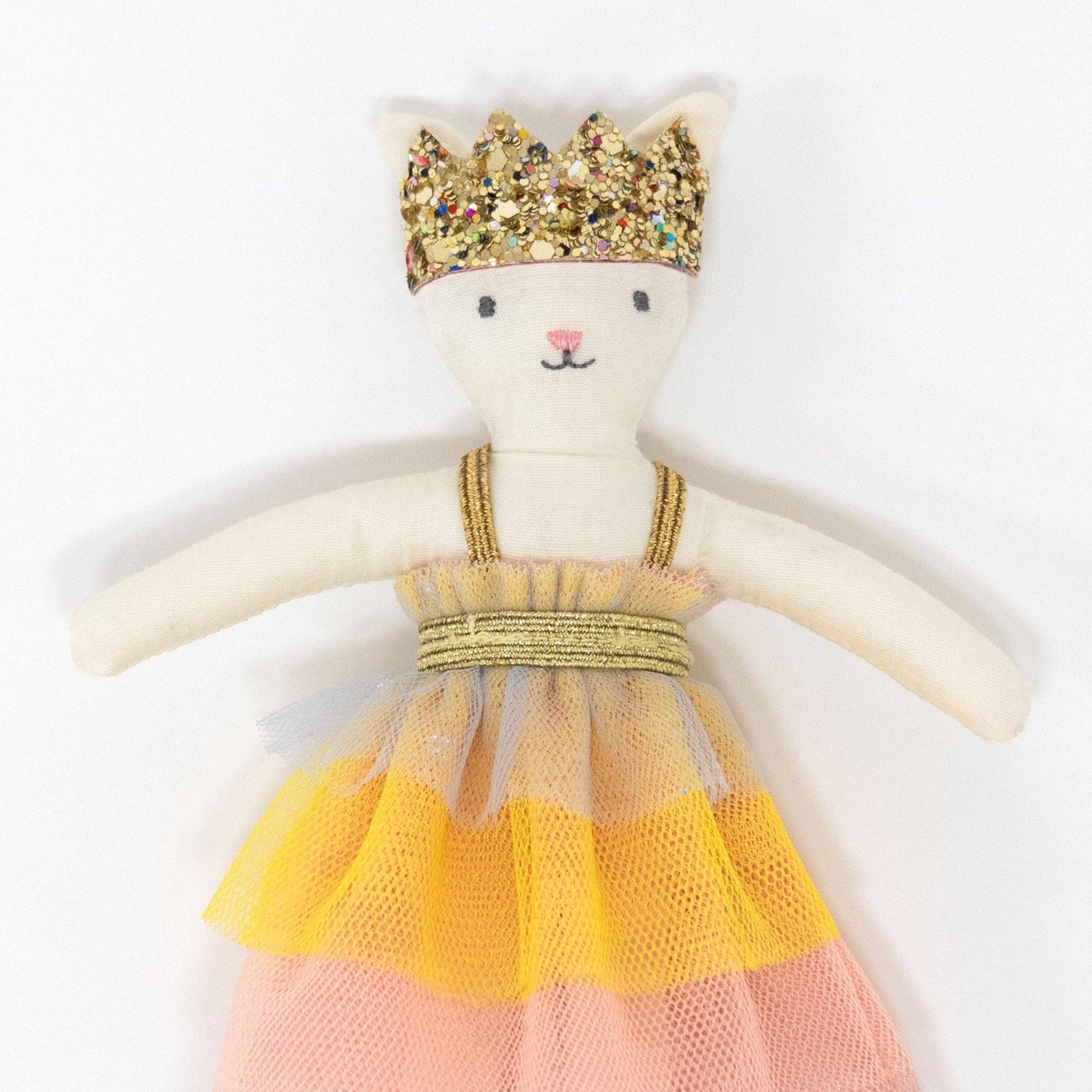 Toy cat with a gold crown and colorful dress on a white background