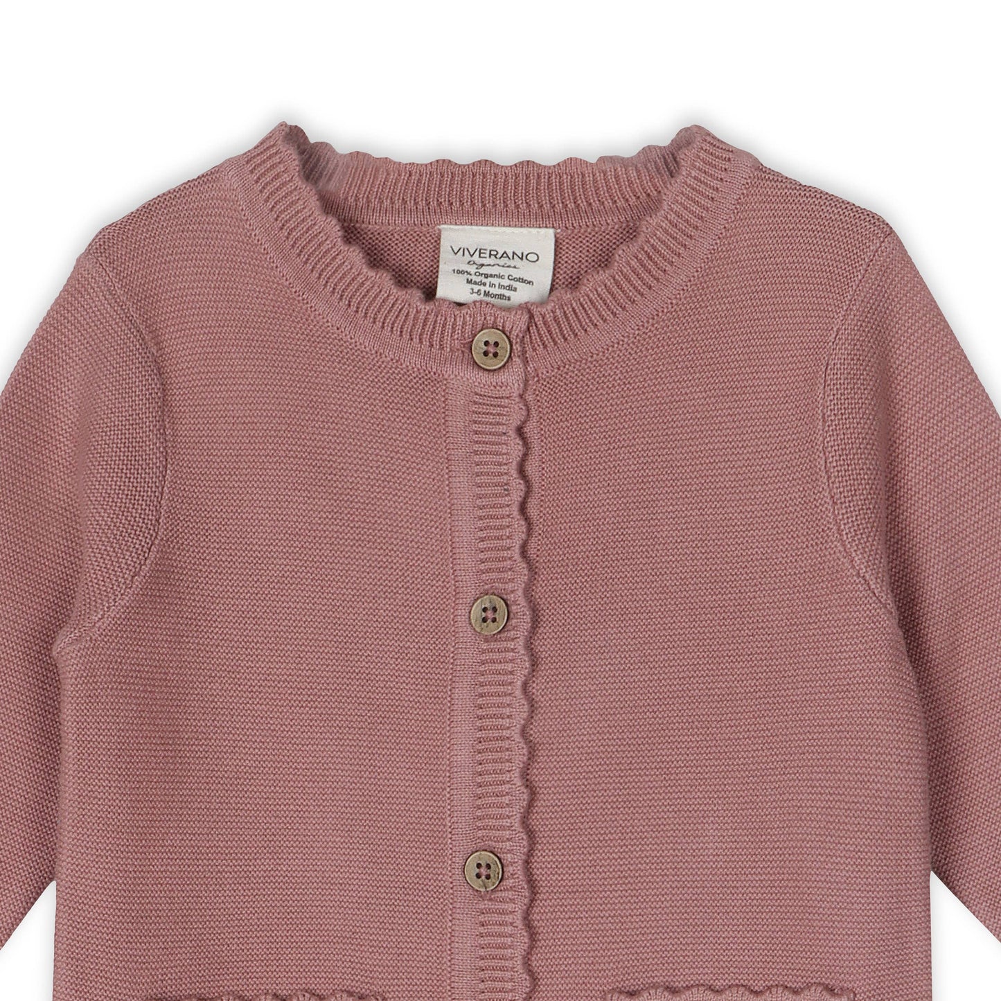 Pink knitted cardigan with button details on a white background