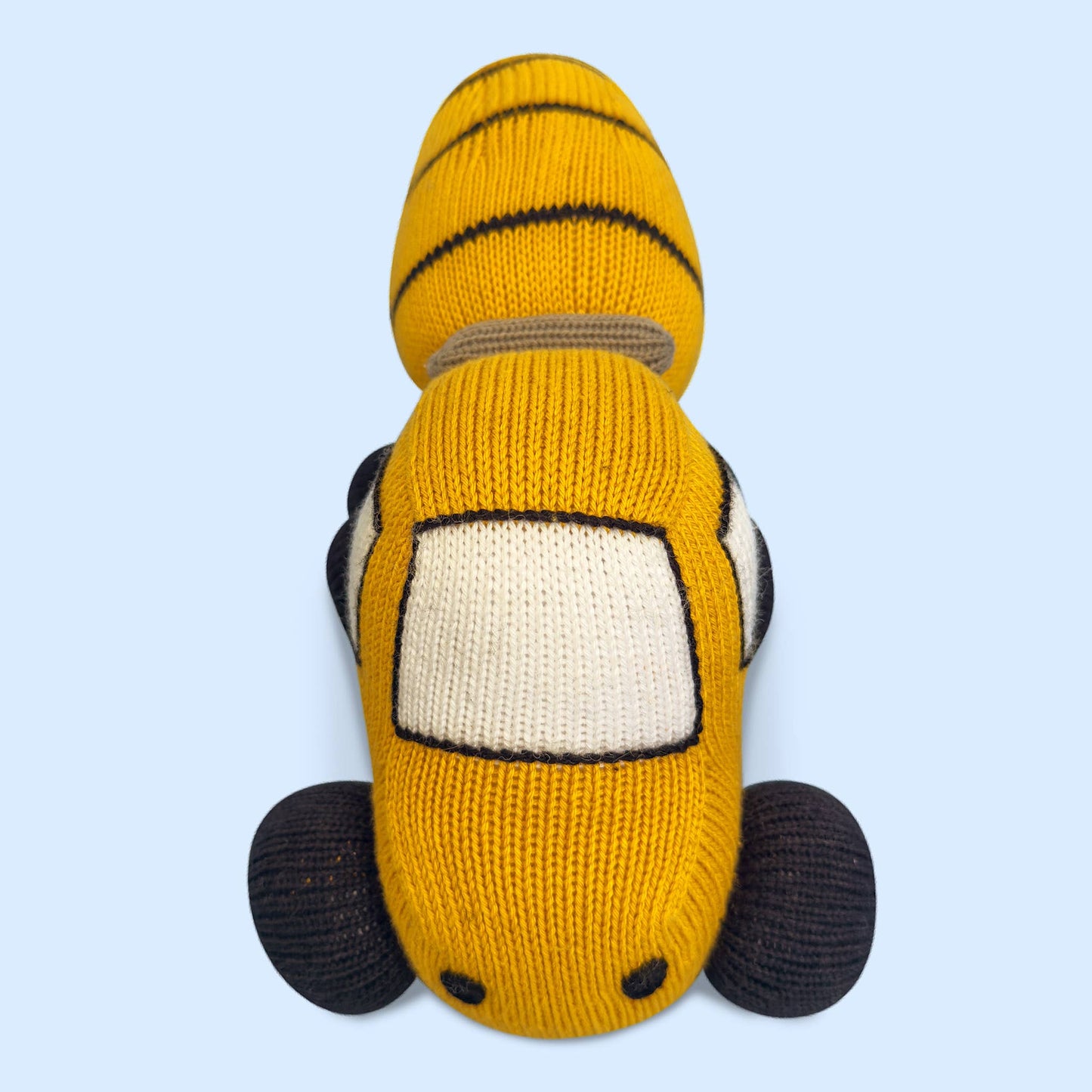 Knitted toy car with a tiger design on a light blue background