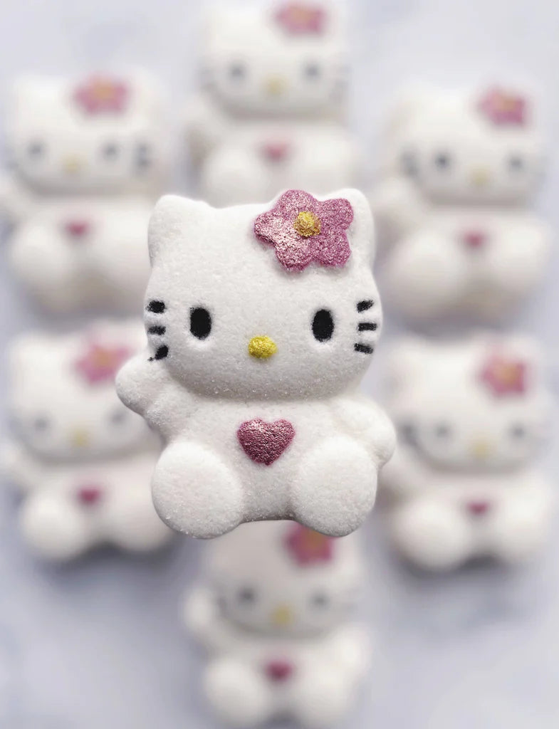 Hello Kitty figurine with a pink flower on its head among other similar figurines.