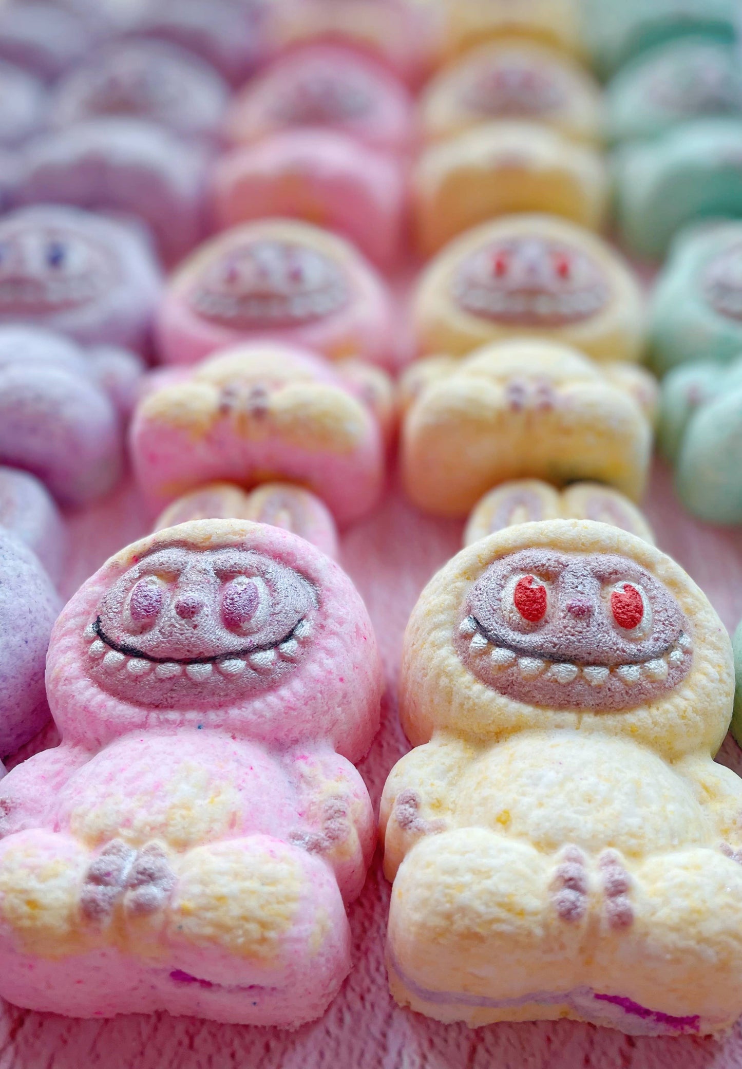 Colorful marshmallow characters shaped like cartoon pigs arranged in a row.