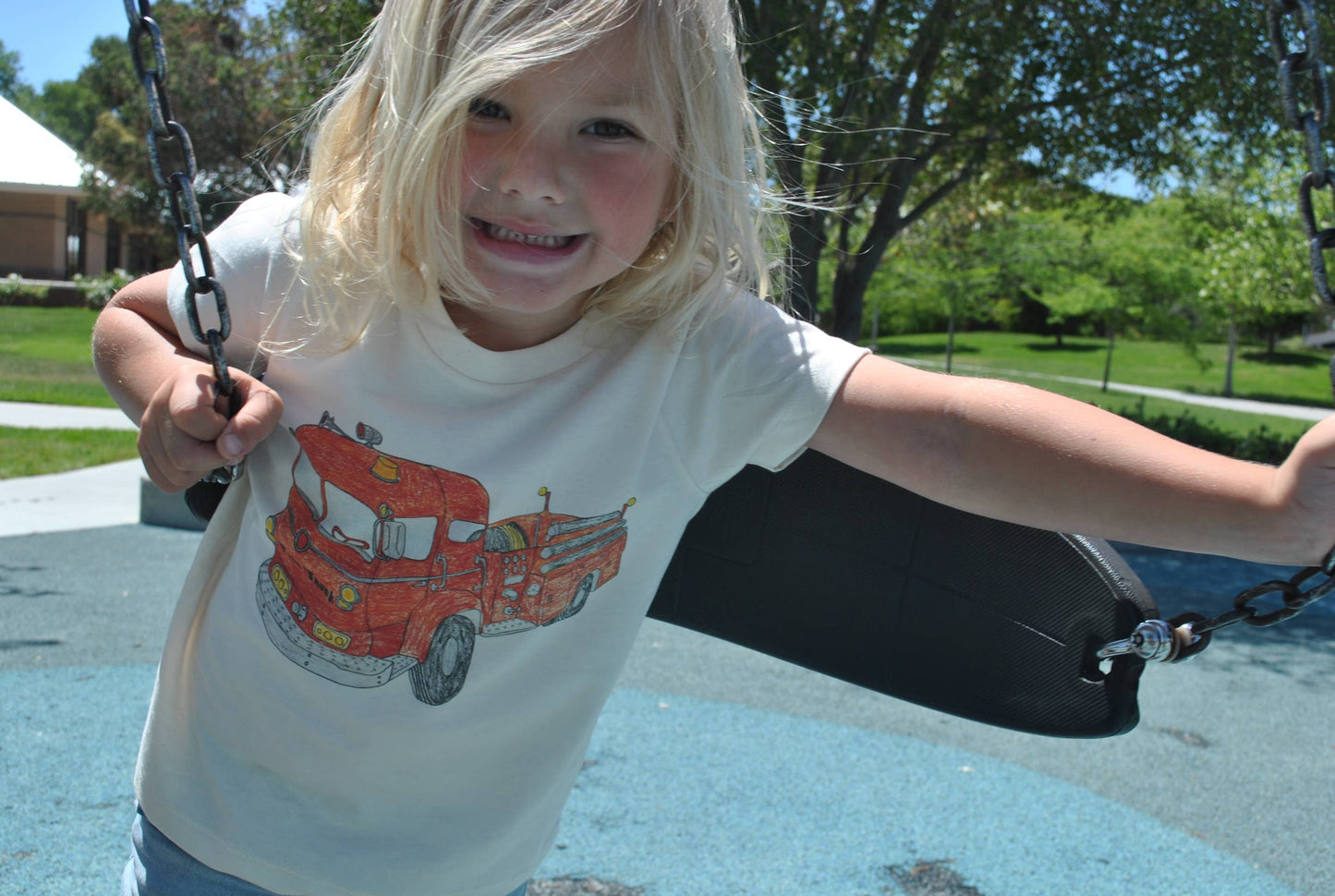 Child on a swing set with a playground in the background