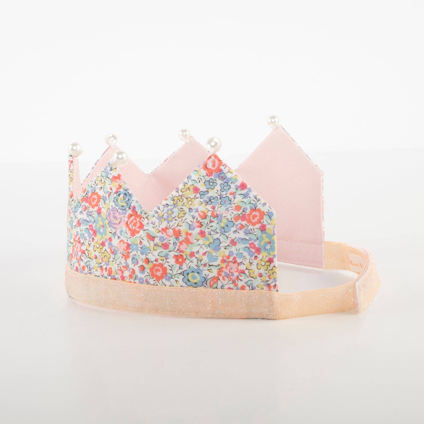 Children's crown with floral design and pink accents on a white background