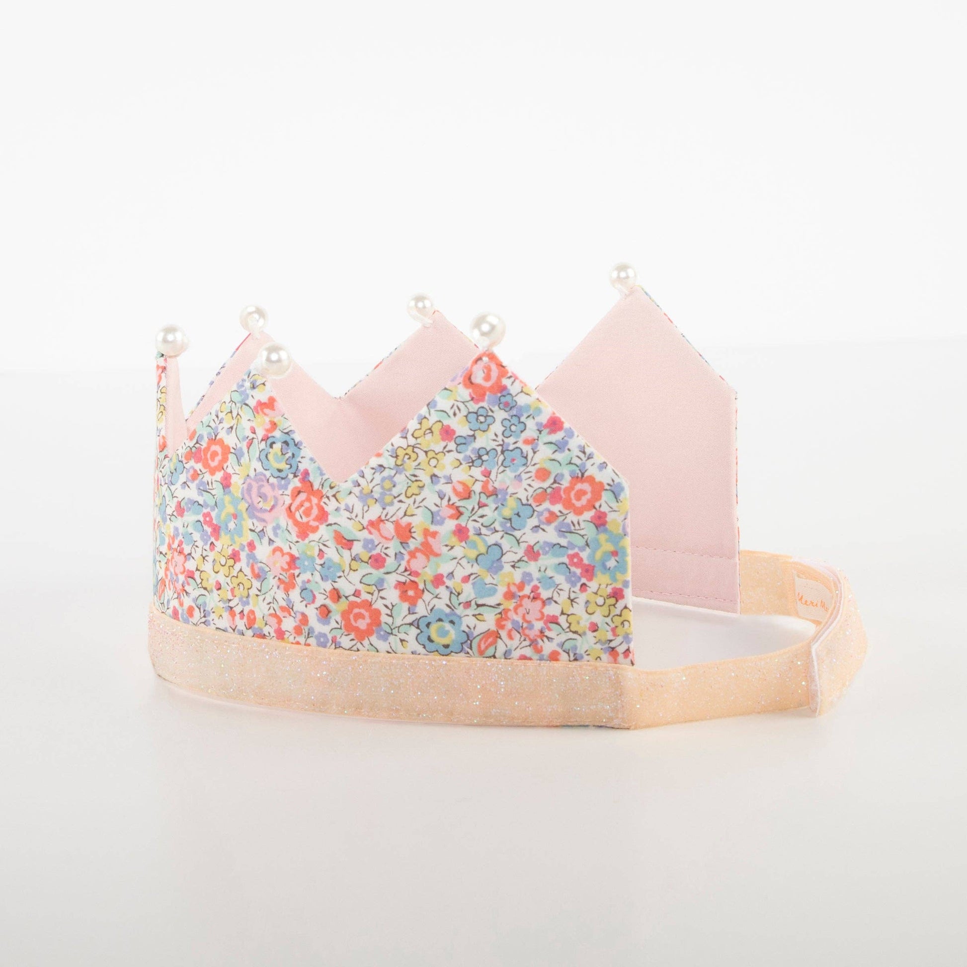 Children's crown with floral design and pink accents on a white background