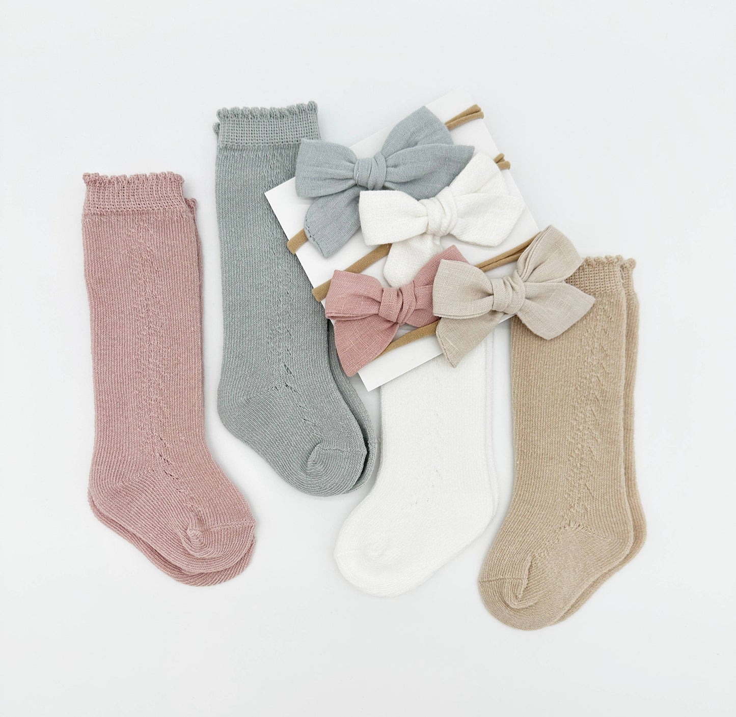 Set of baby socks with bow details on a light gray background
