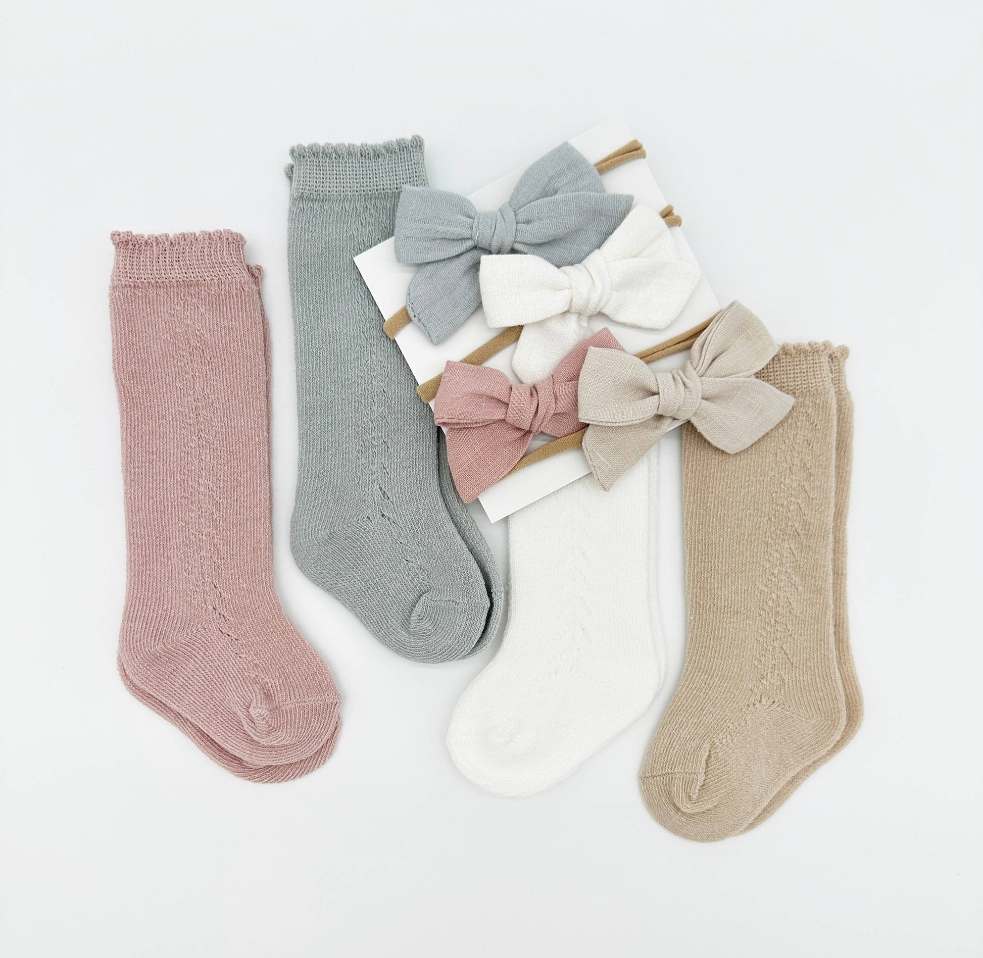 Set of baby socks with bow details on a light gray background