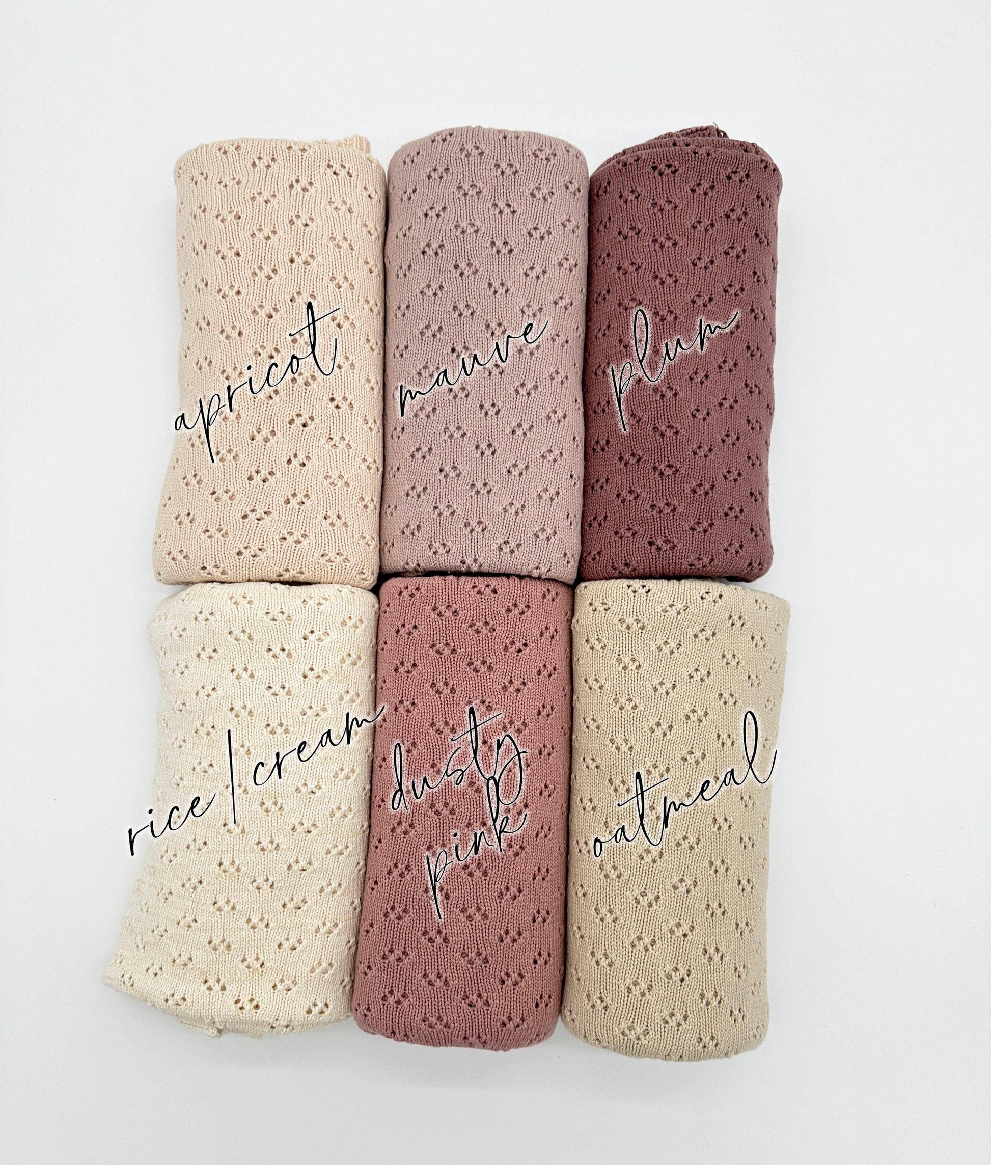 Set of five folded fabrics in different colors with text labels on a white background