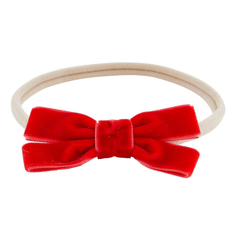 Red velvet bow headband on a white background