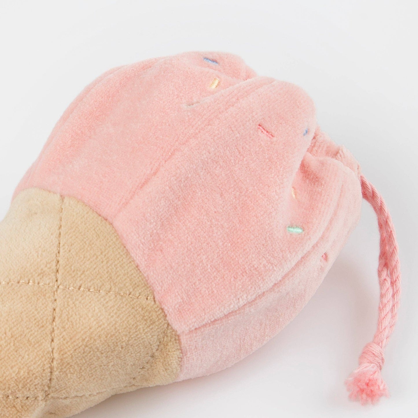 Plush toy with pink top and beige bottom on a white background