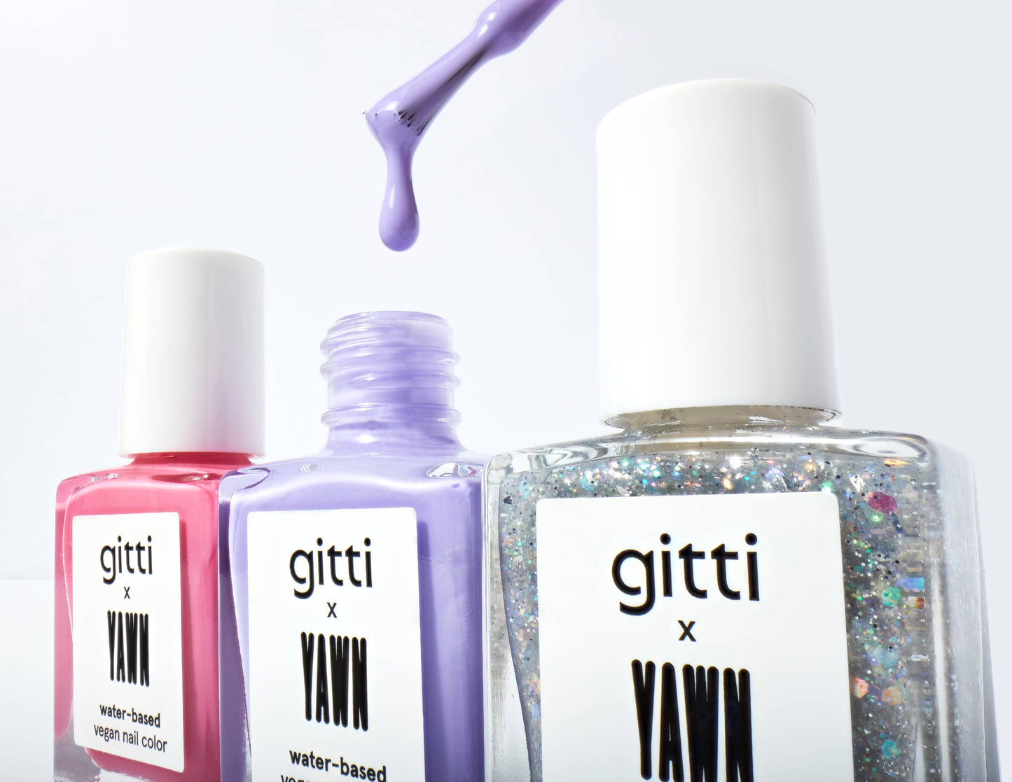 Three bottles of gitti x Yawn nail polish with a white background