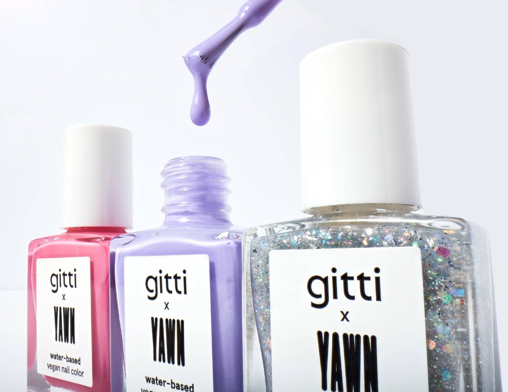 Three bottles of gitti x Yawn nail polish with a white background