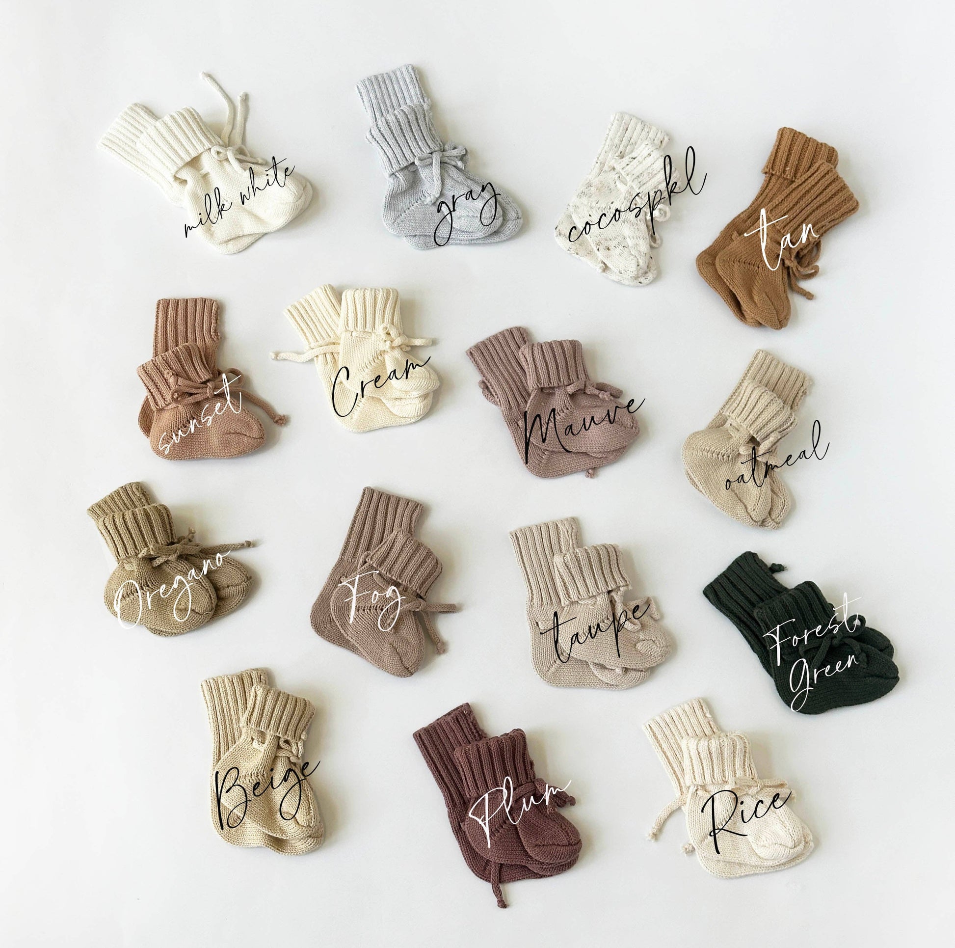 Collection of baby socks in various colors with name labels on a white background