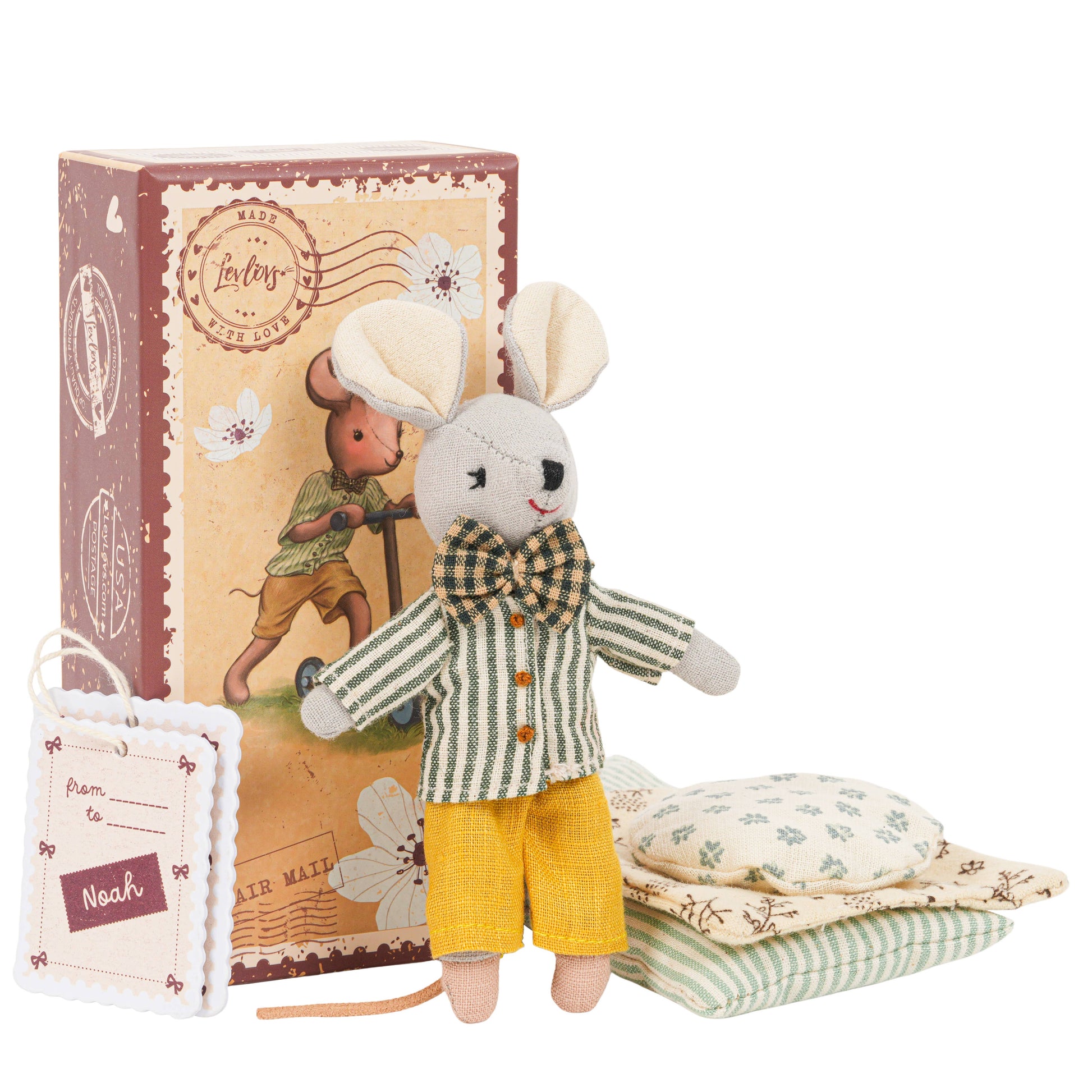 Toy mouse in a outfit with a decorative box and pillows on a white background